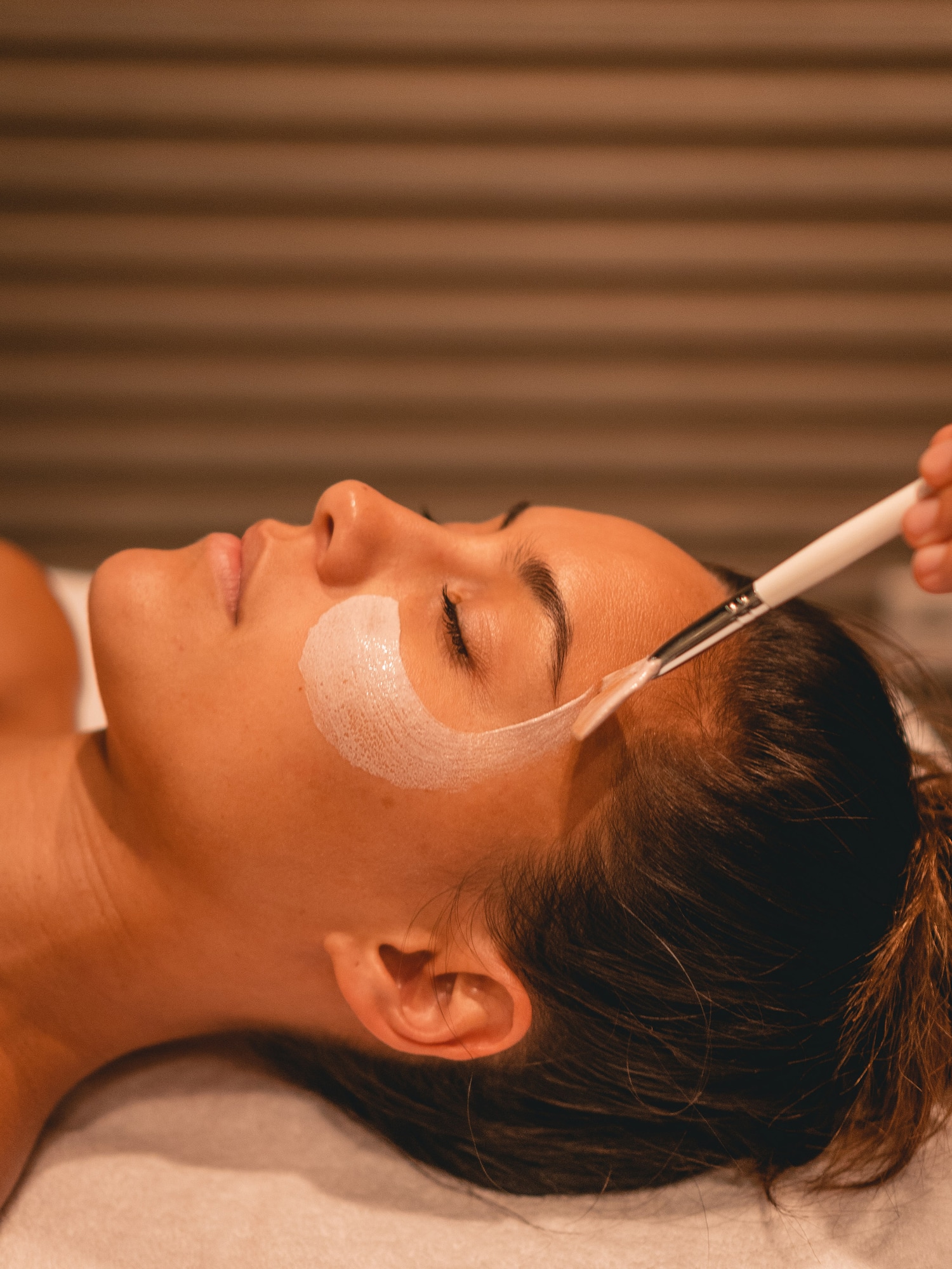 a woman lying down with a brush on her face