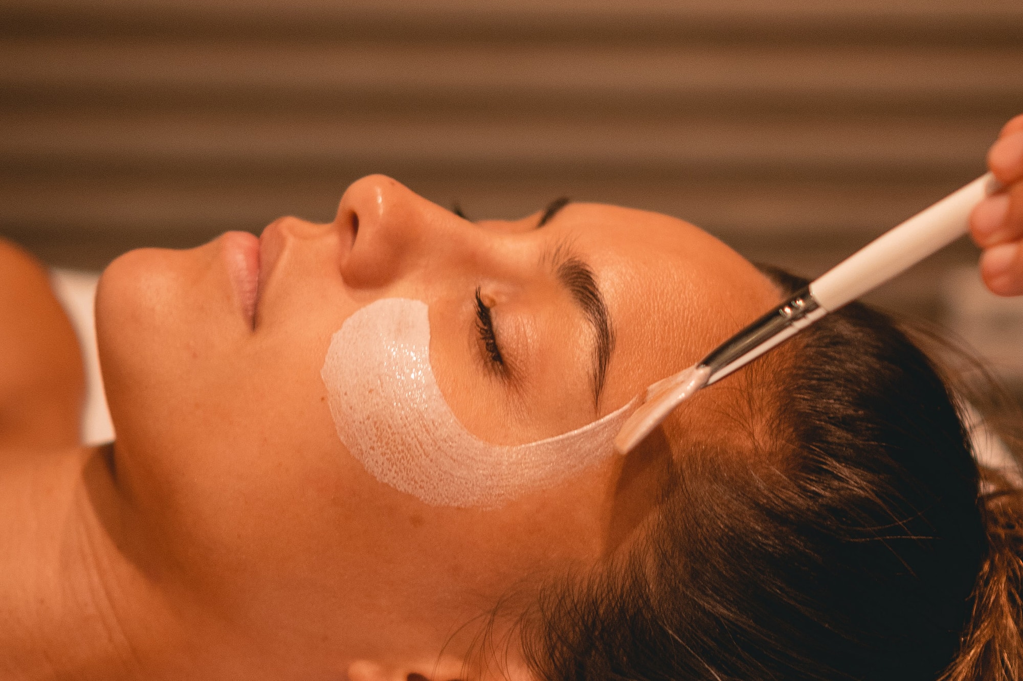 a woman lying down with a brush on her face