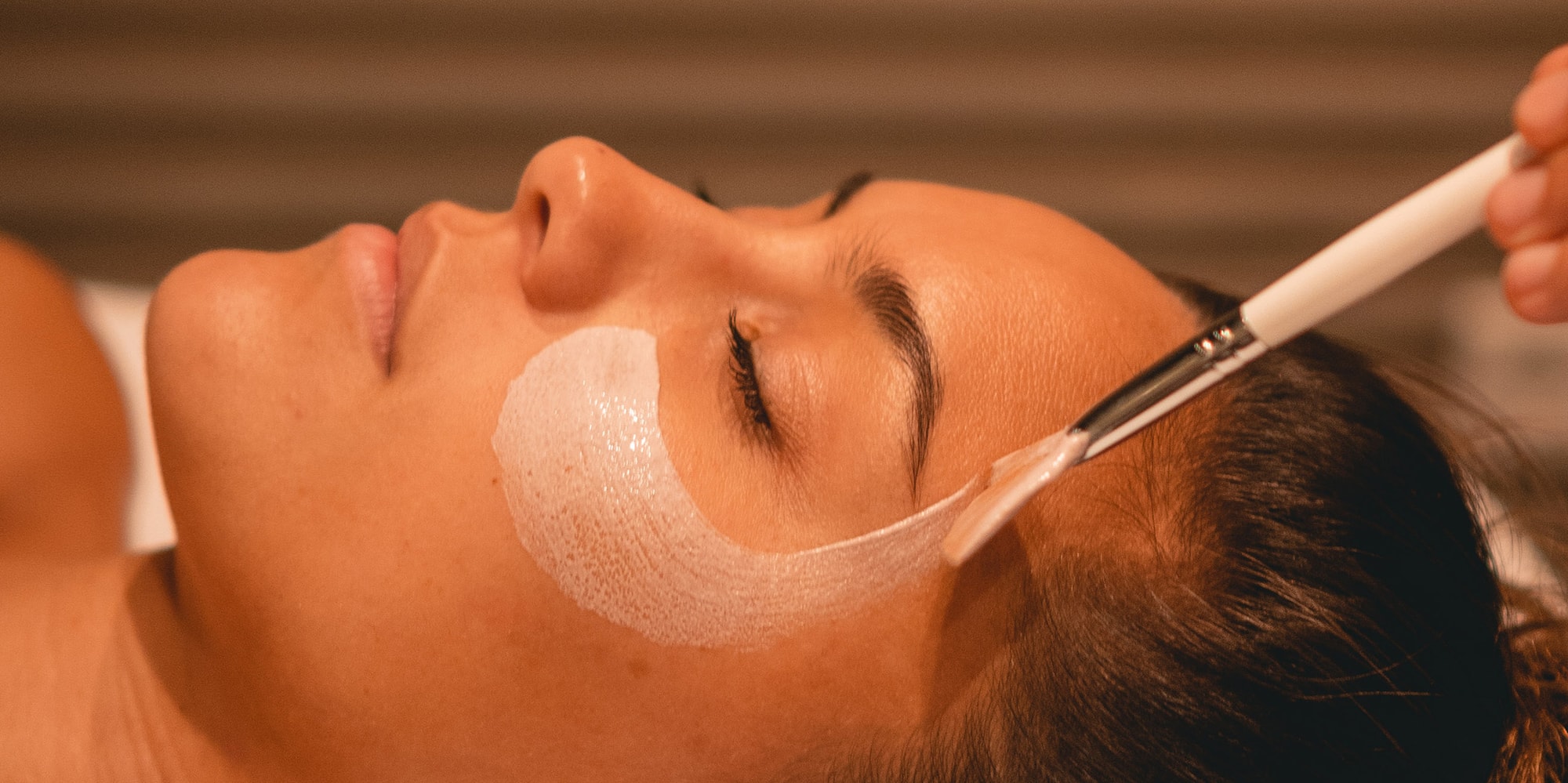 a woman lying down with a brush on her face