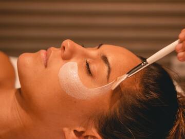 a woman lying down with a brush on her face