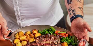 a person holding a pan of food