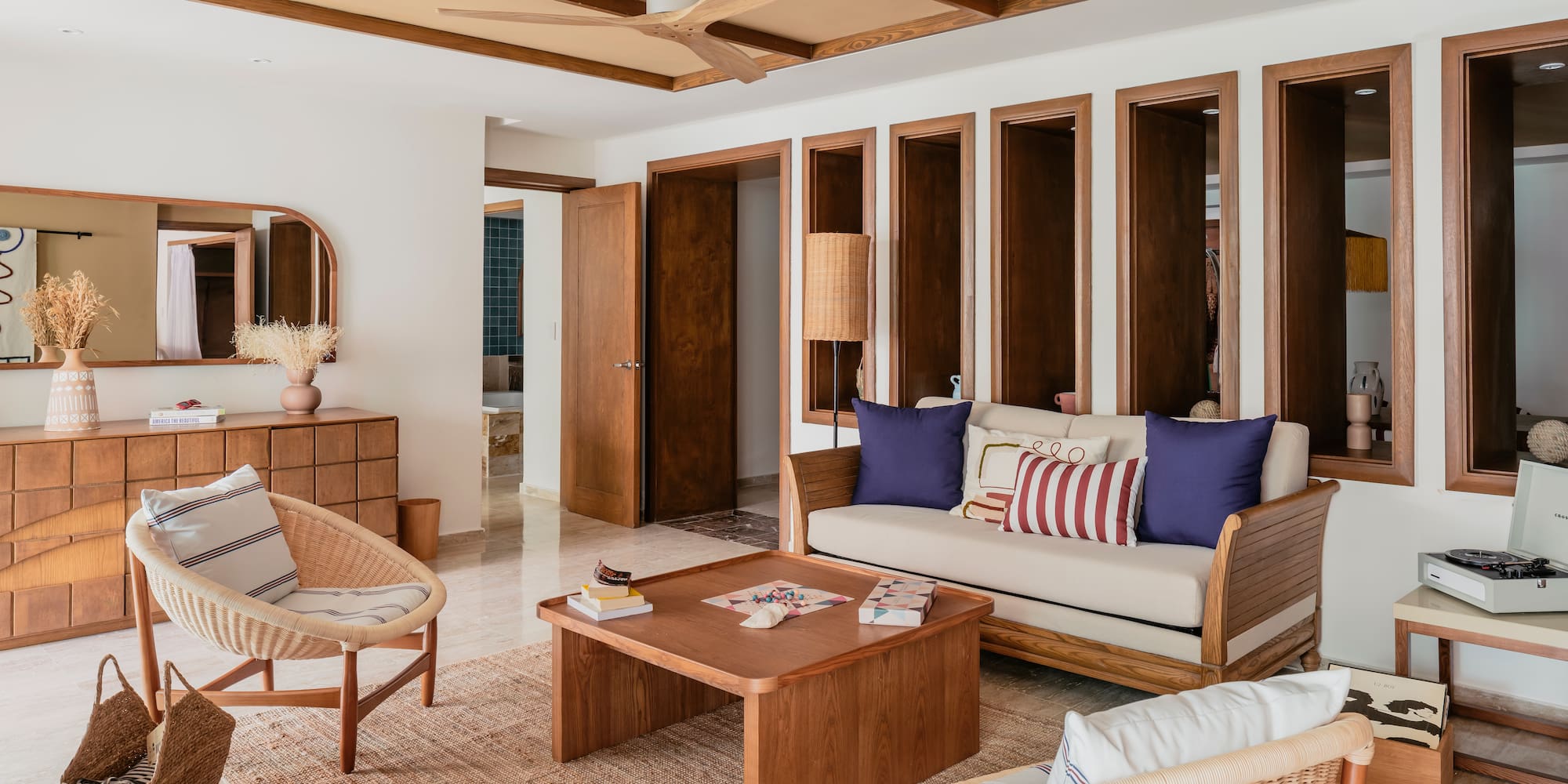 Modern bohemian living room with wood and rattan furniture, neutral tones.