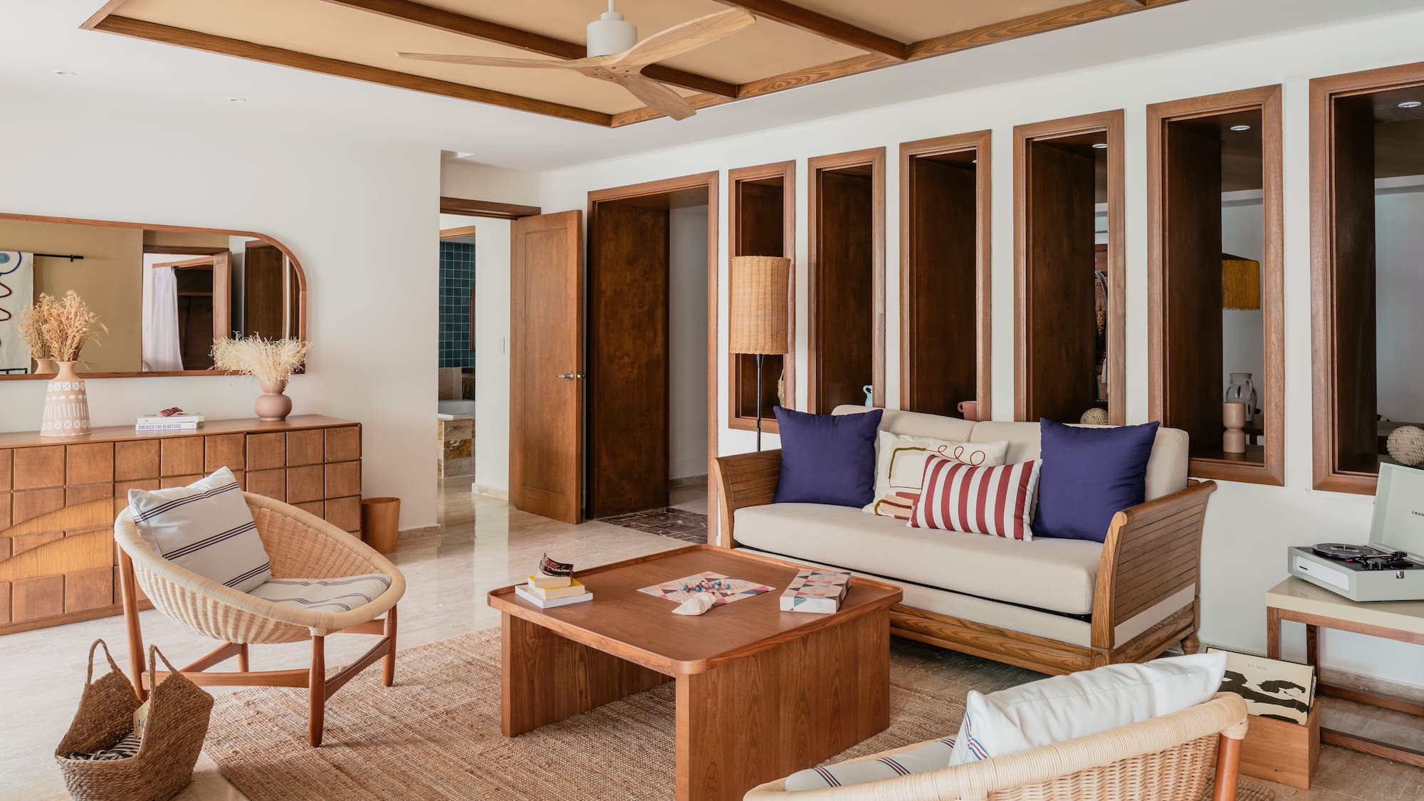 Modern living room with wood furniture, wicker chairs, and neutral decor.