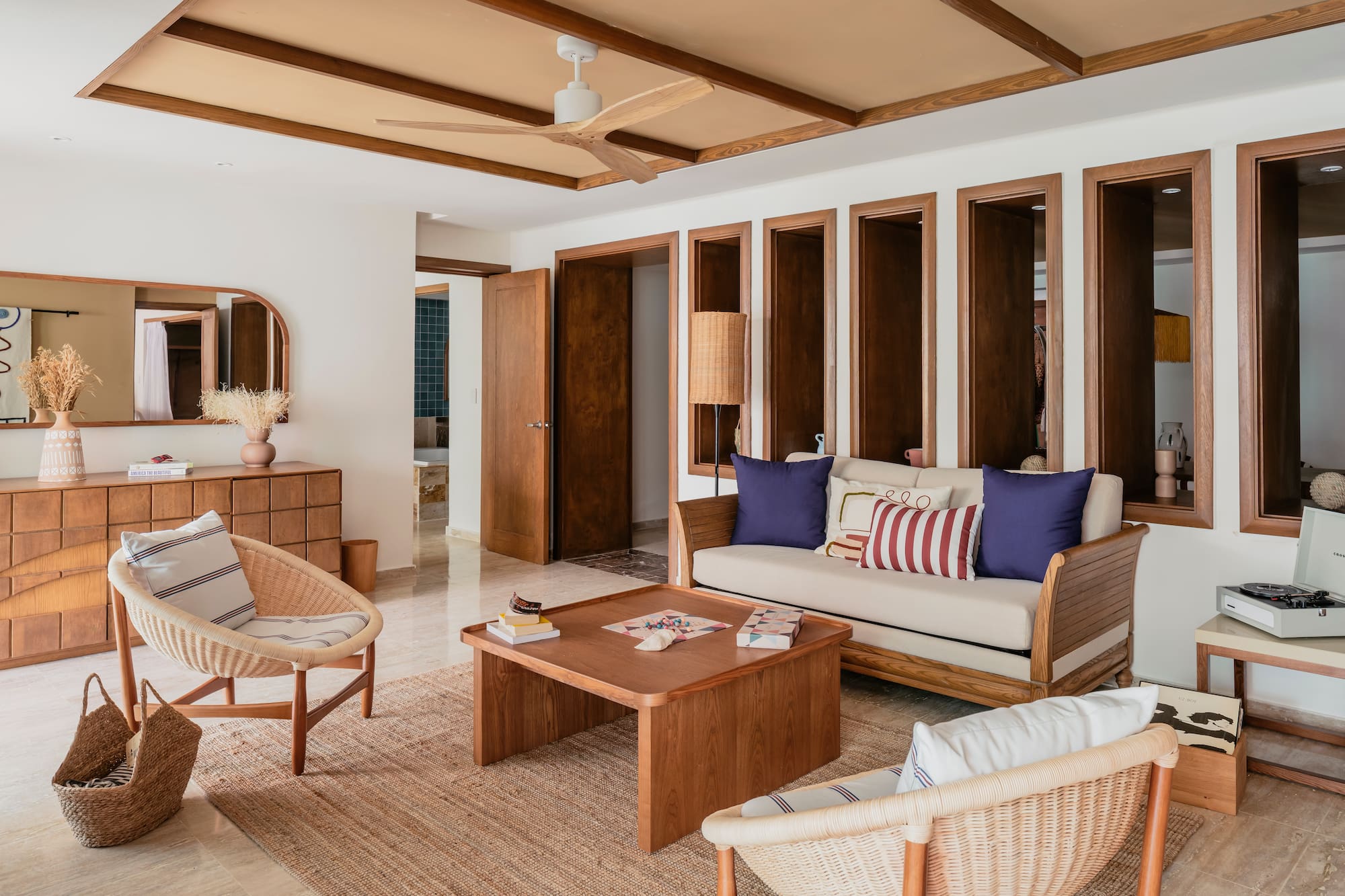 Modern living room with wood furniture, wicker chairs, and neutral decor.
