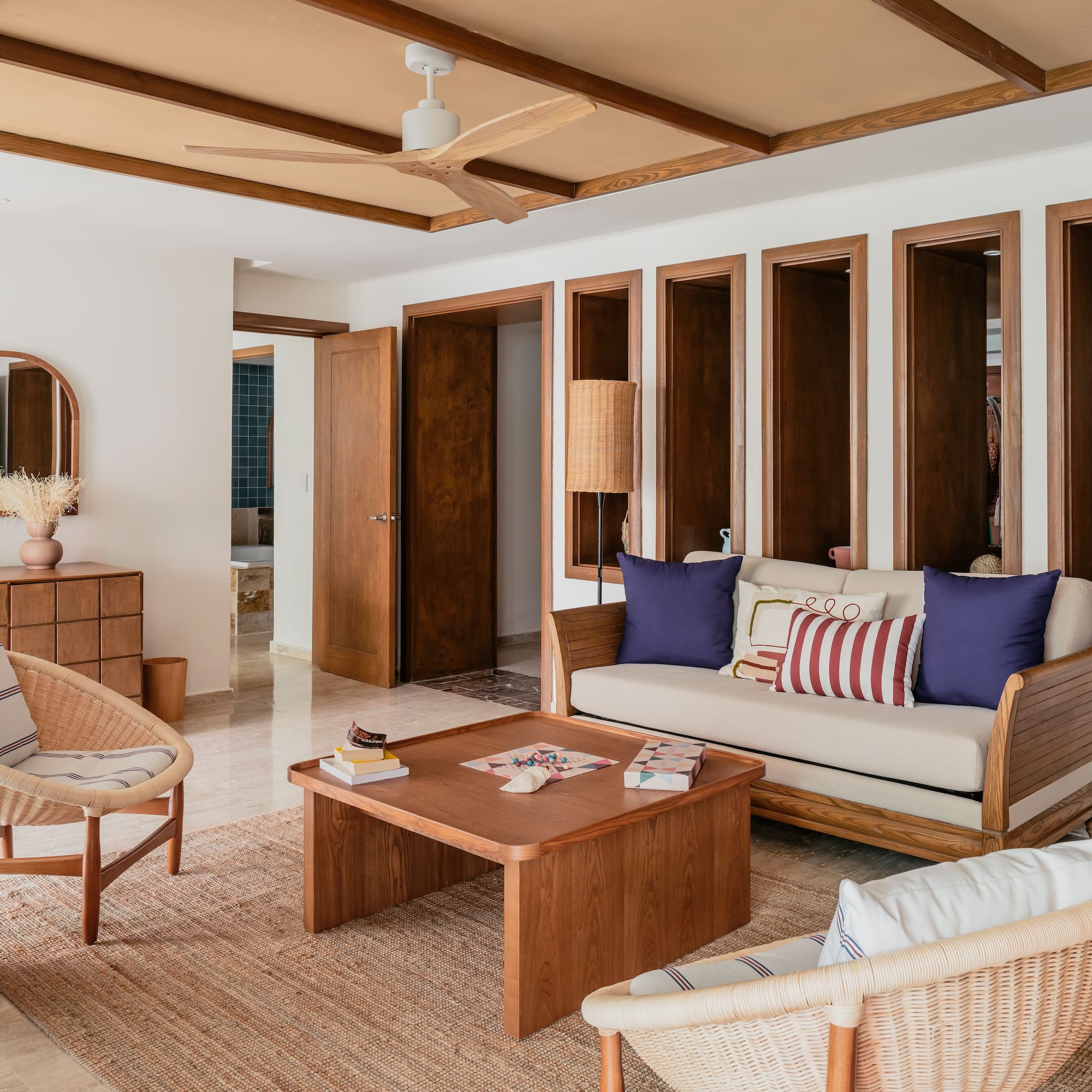 Modern living room with wood furniture, wicker chairs, and neutral decor.