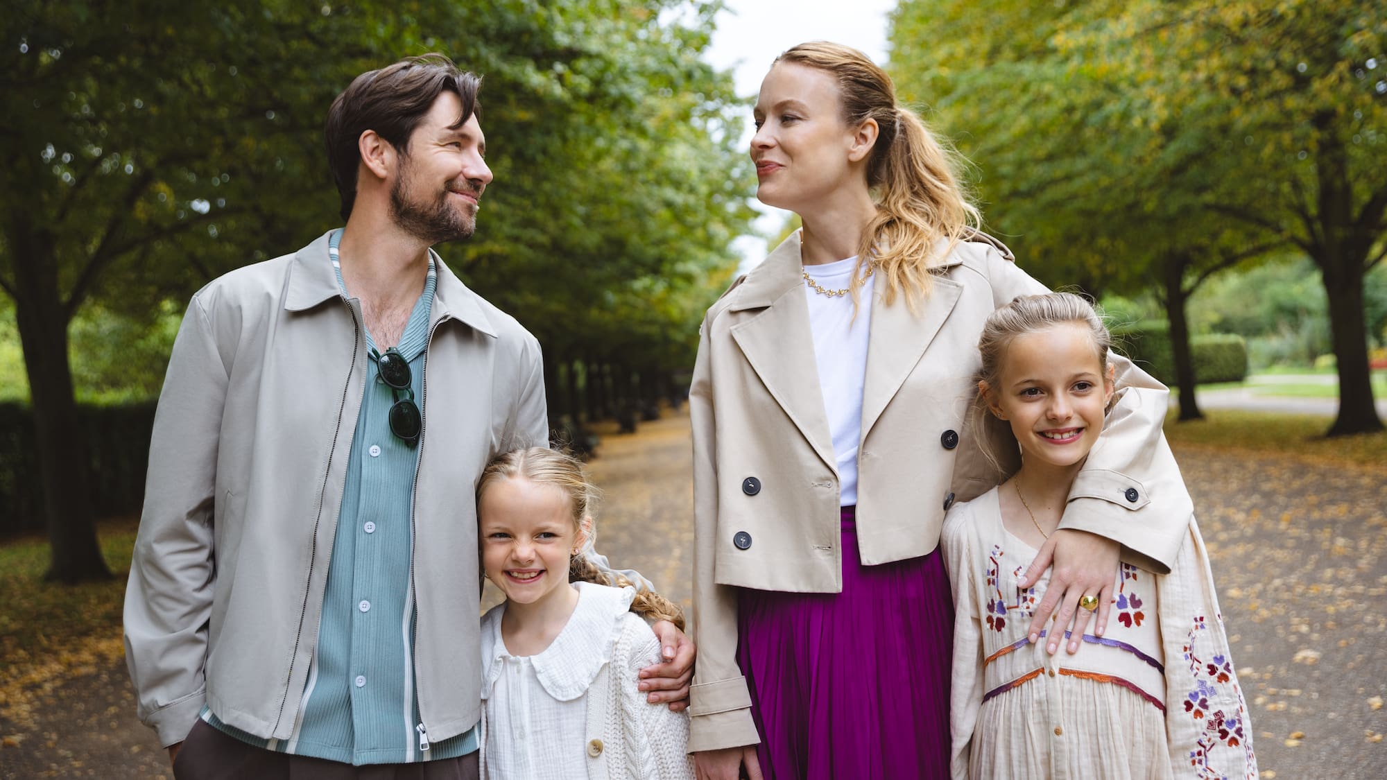 a man and woman standing together with two children