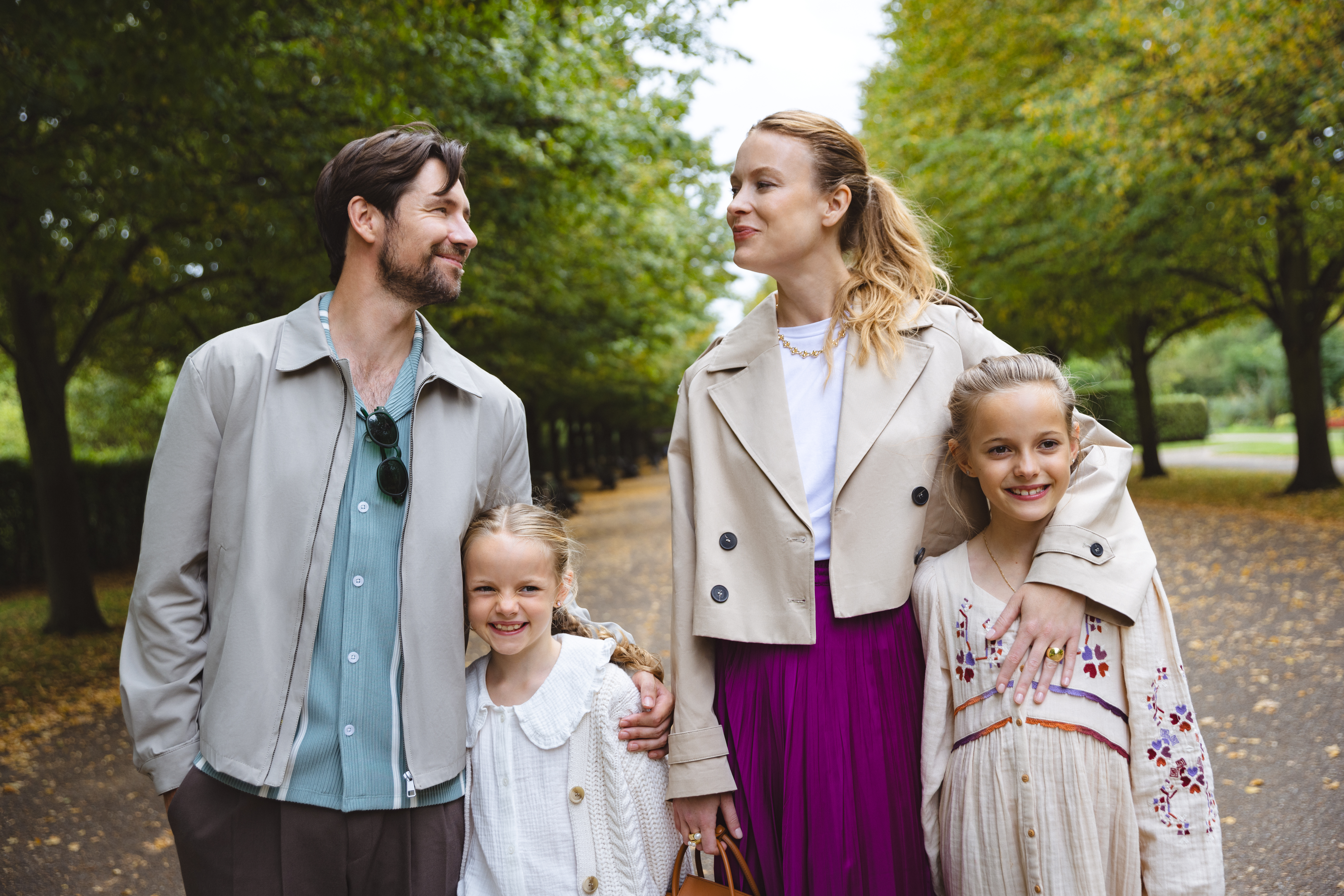 a man and woman standing together with two children