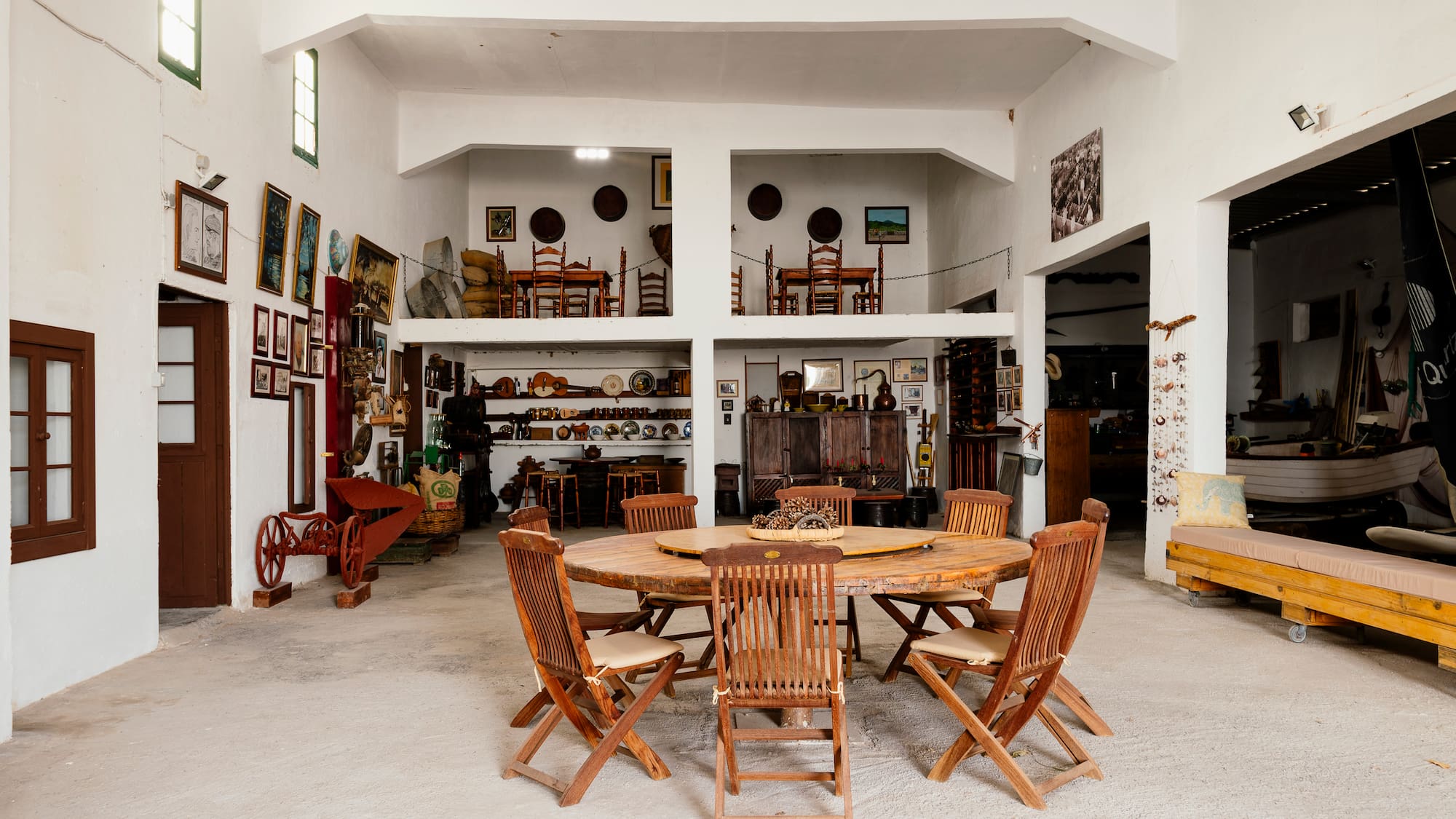 Rustic hall with large wooden table, traditional style, and antique displays.