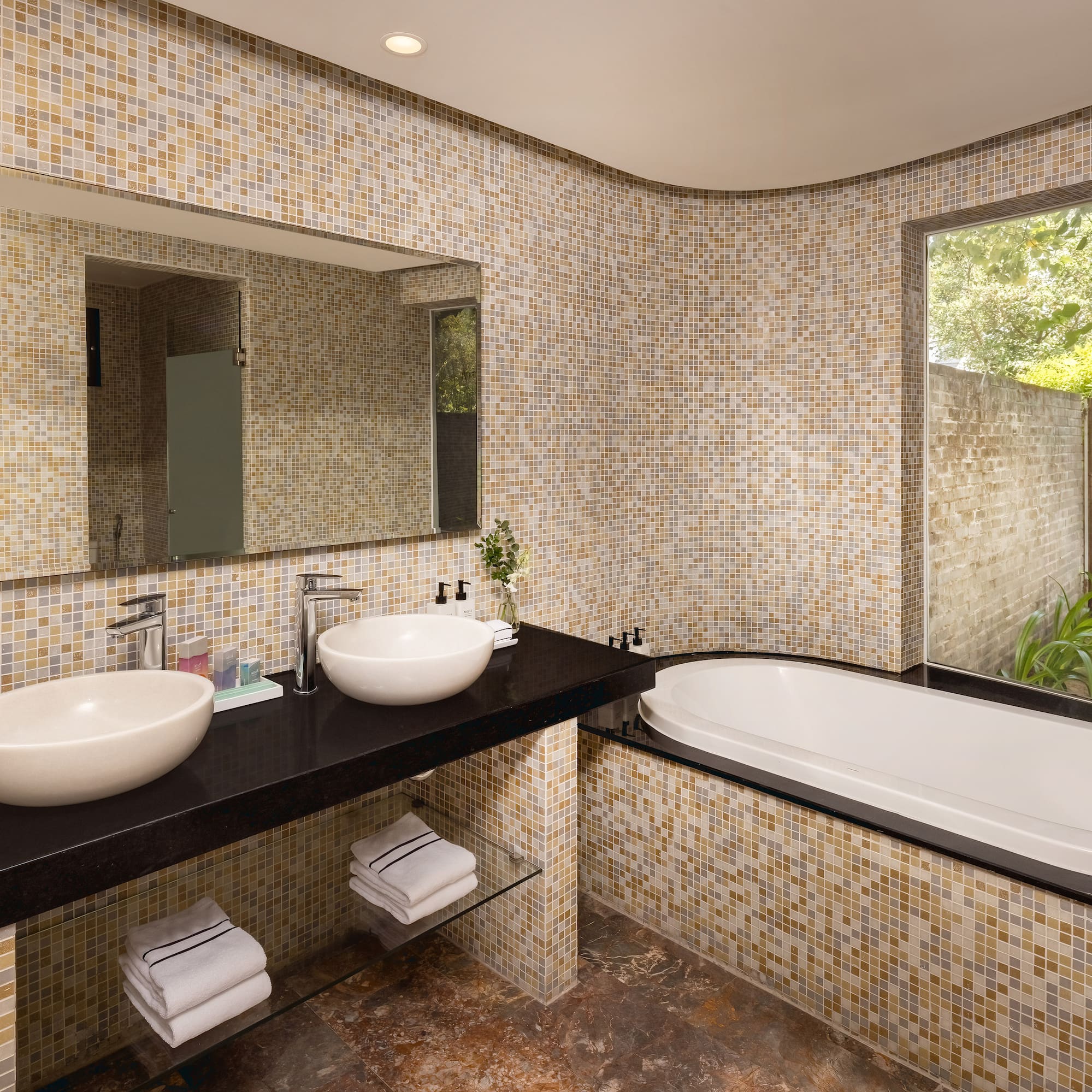 a bathroom with a tub and sinks