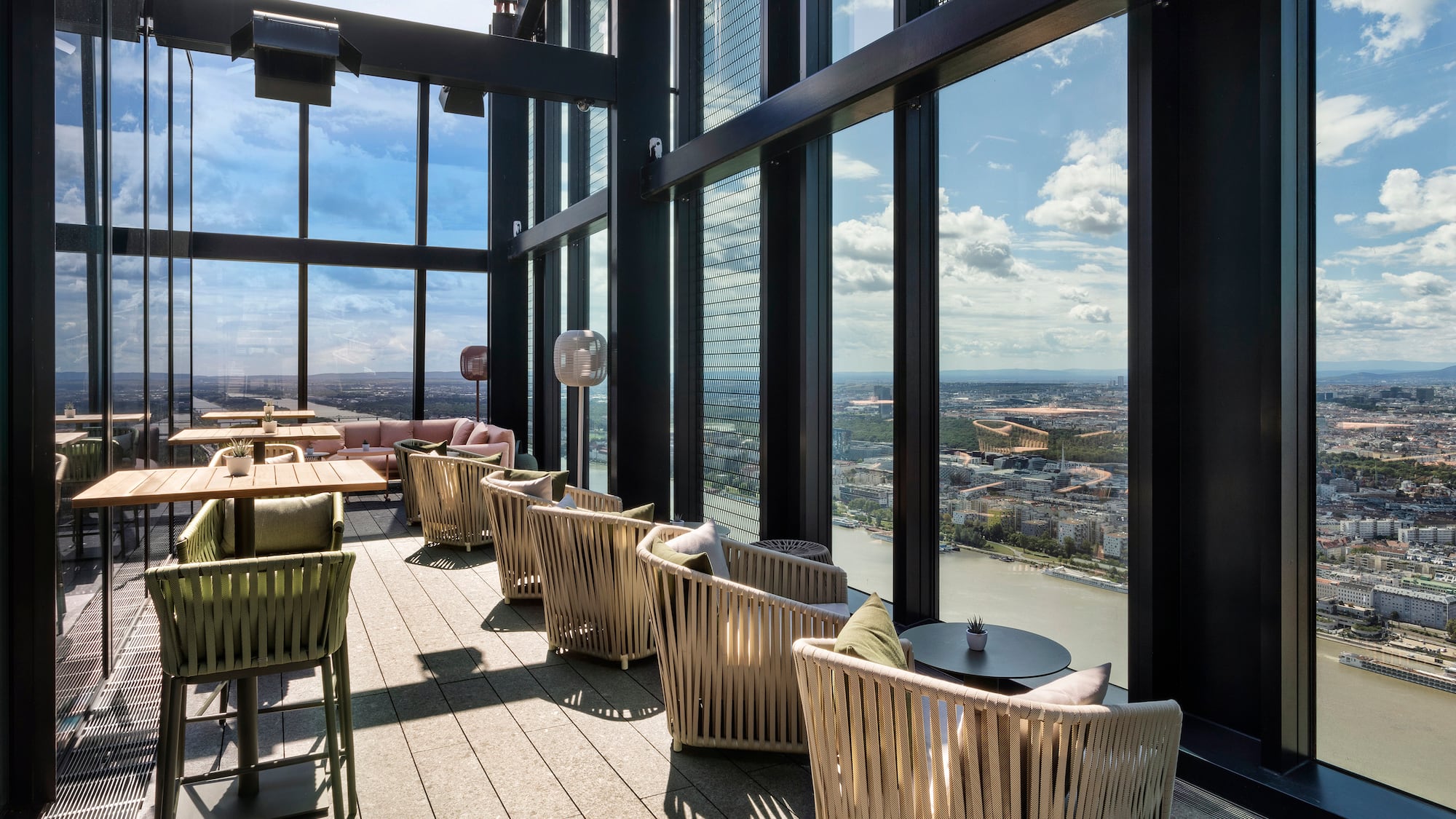 a room with chairs and tables and a view of a city