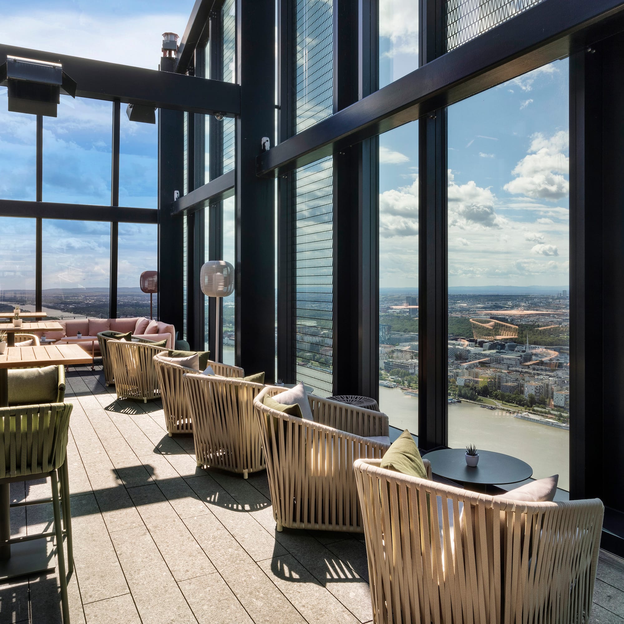 a room with chairs and tables and a view of a city