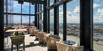 a room with chairs and tables and a view of a city