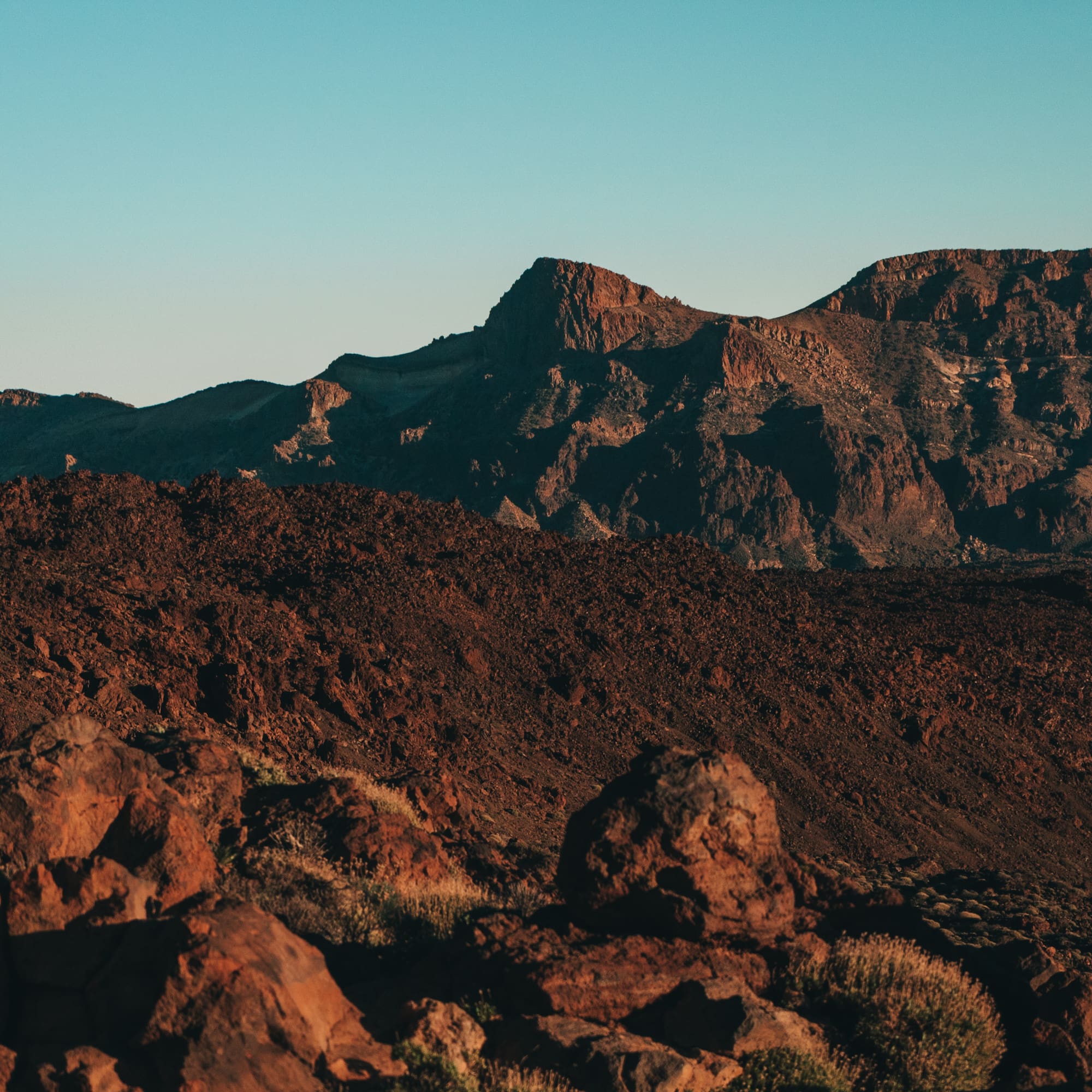 a rocky mountains with a blue sky