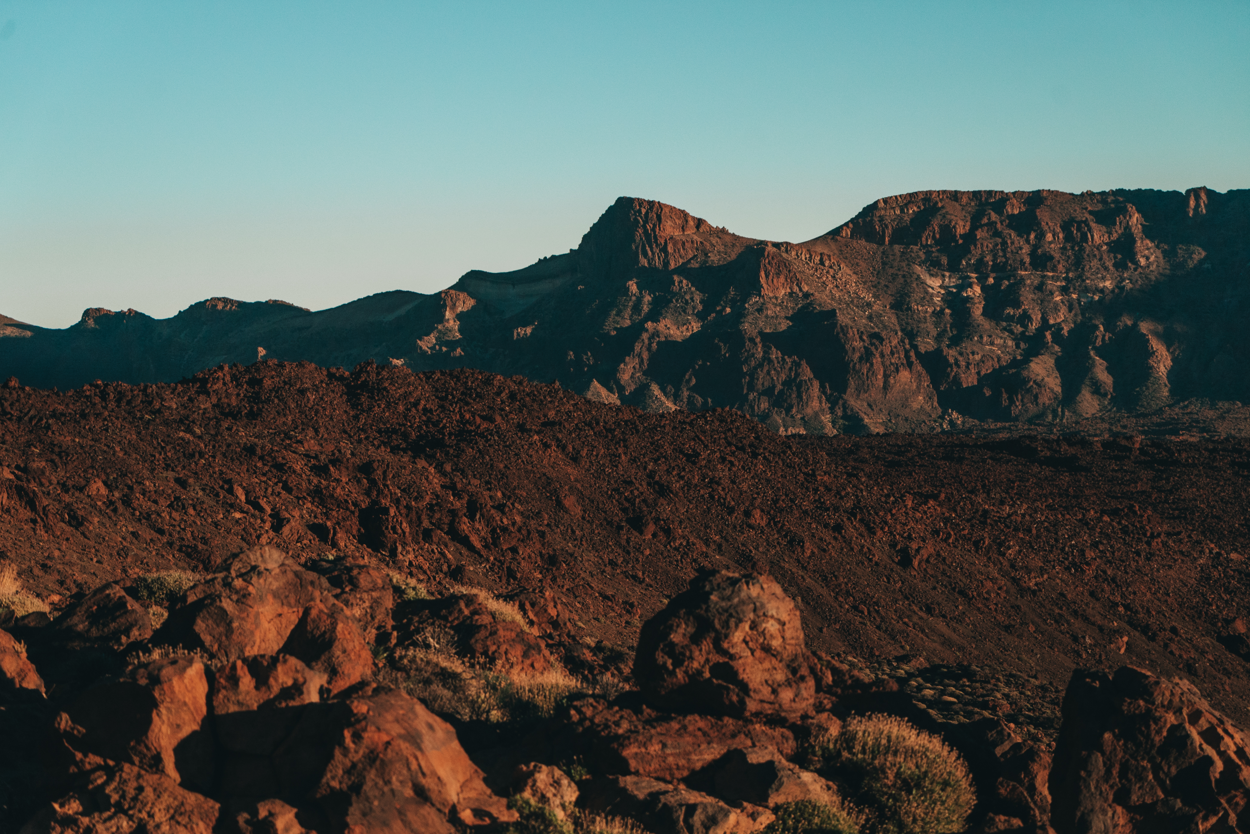 a rocky mountains with a blue sky