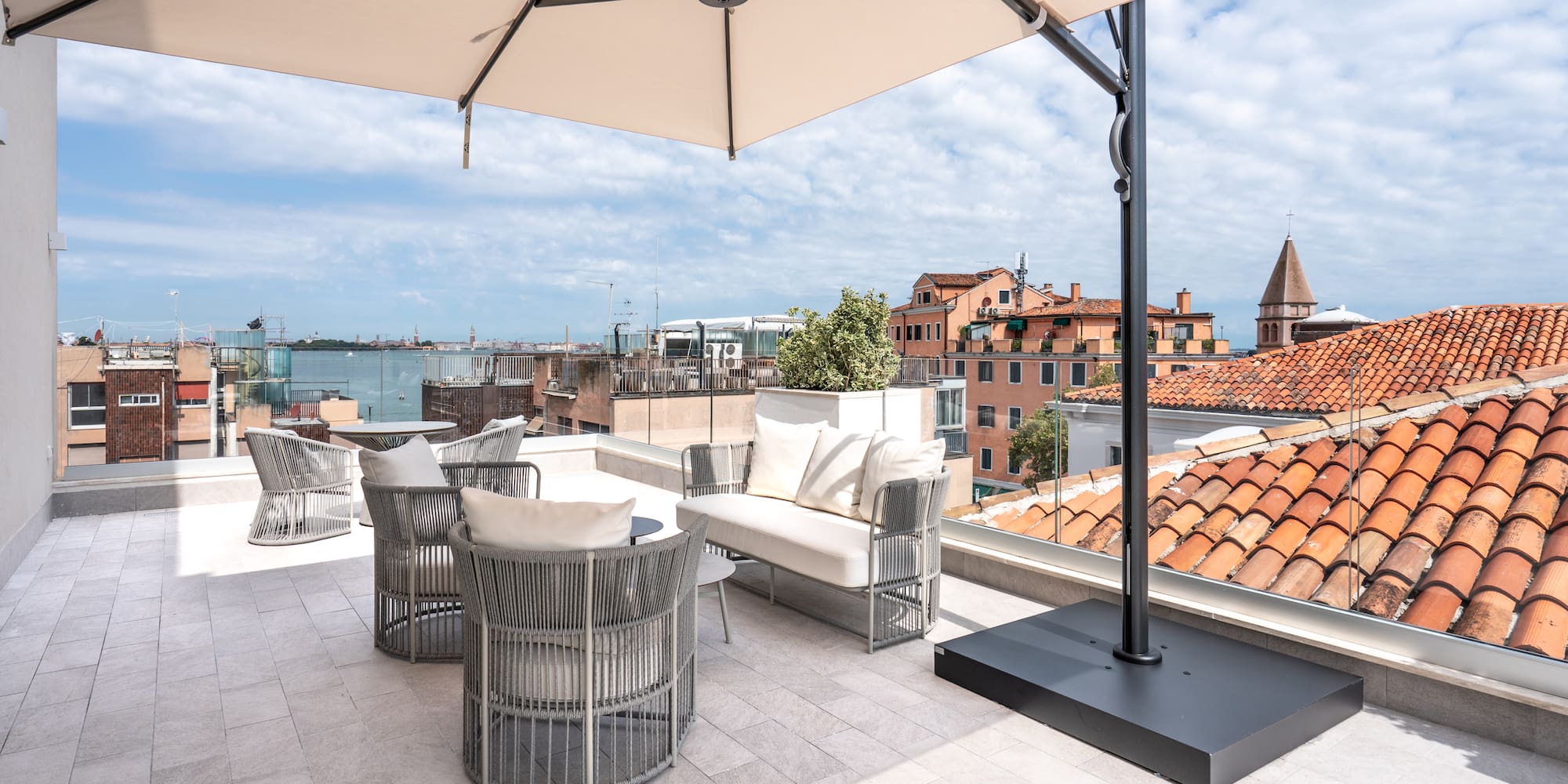 a patio with a white umbrella and chairs