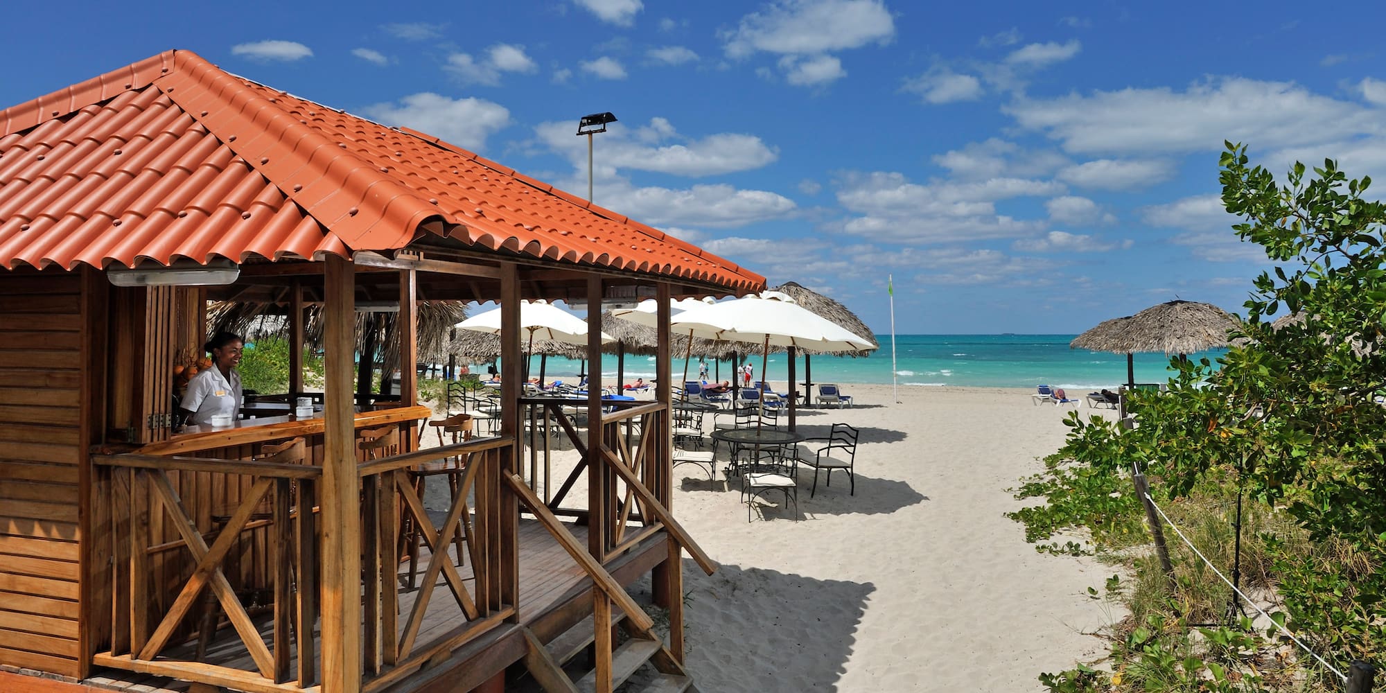 a beach with umbrellas and a gazebo