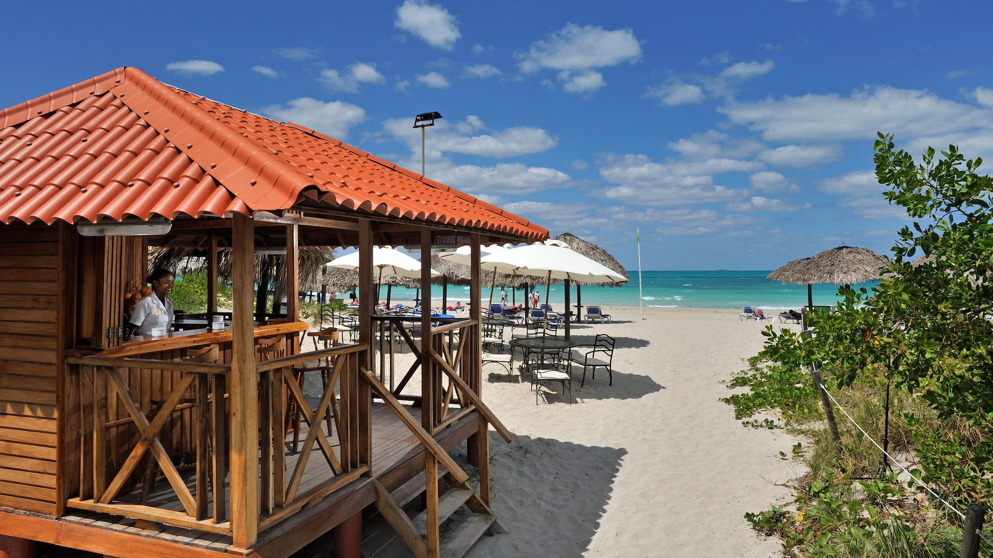 a beach with umbrellas and a gazebo