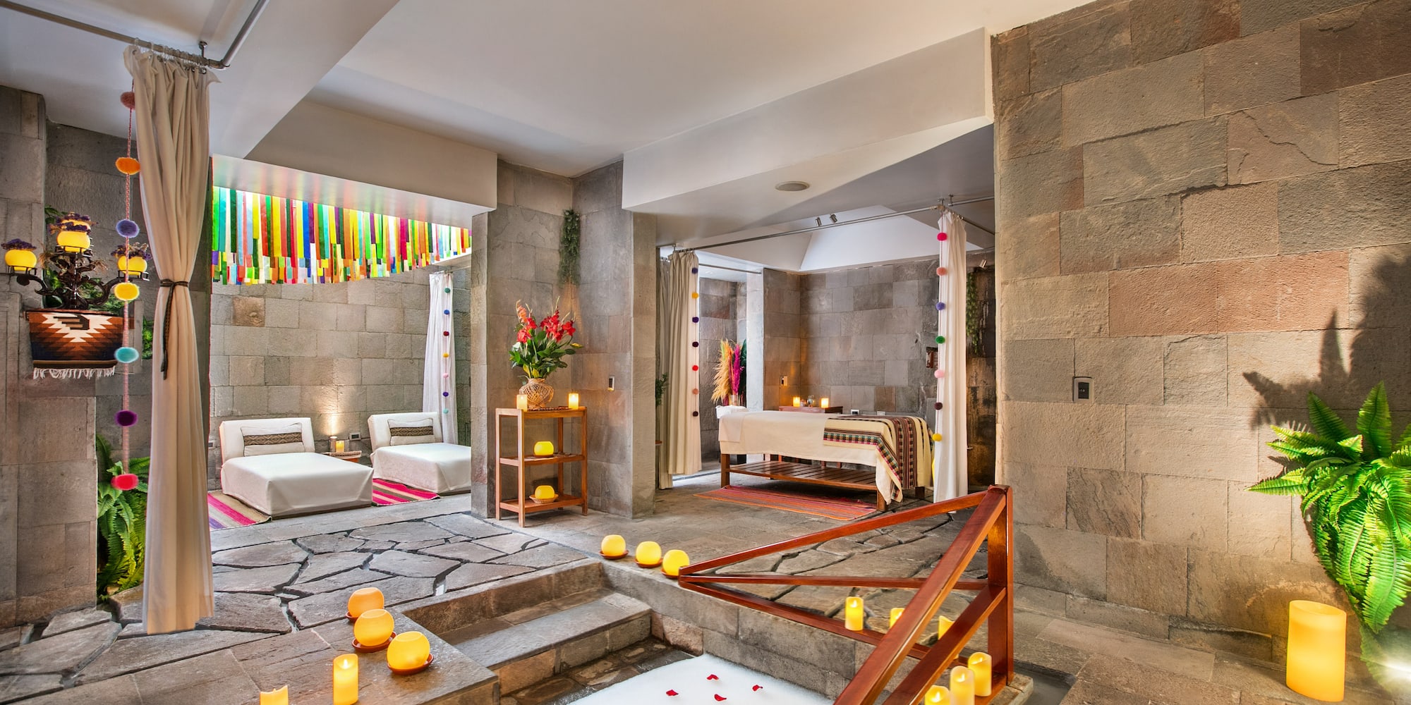 Andean luxury spa with stone walls, rose petal bath, and massage area.
