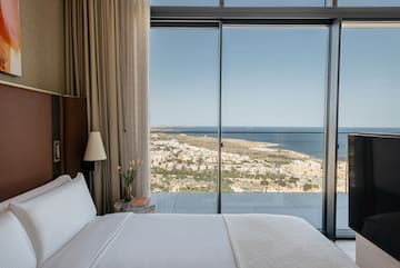 a bed with a view of the ocean and a city