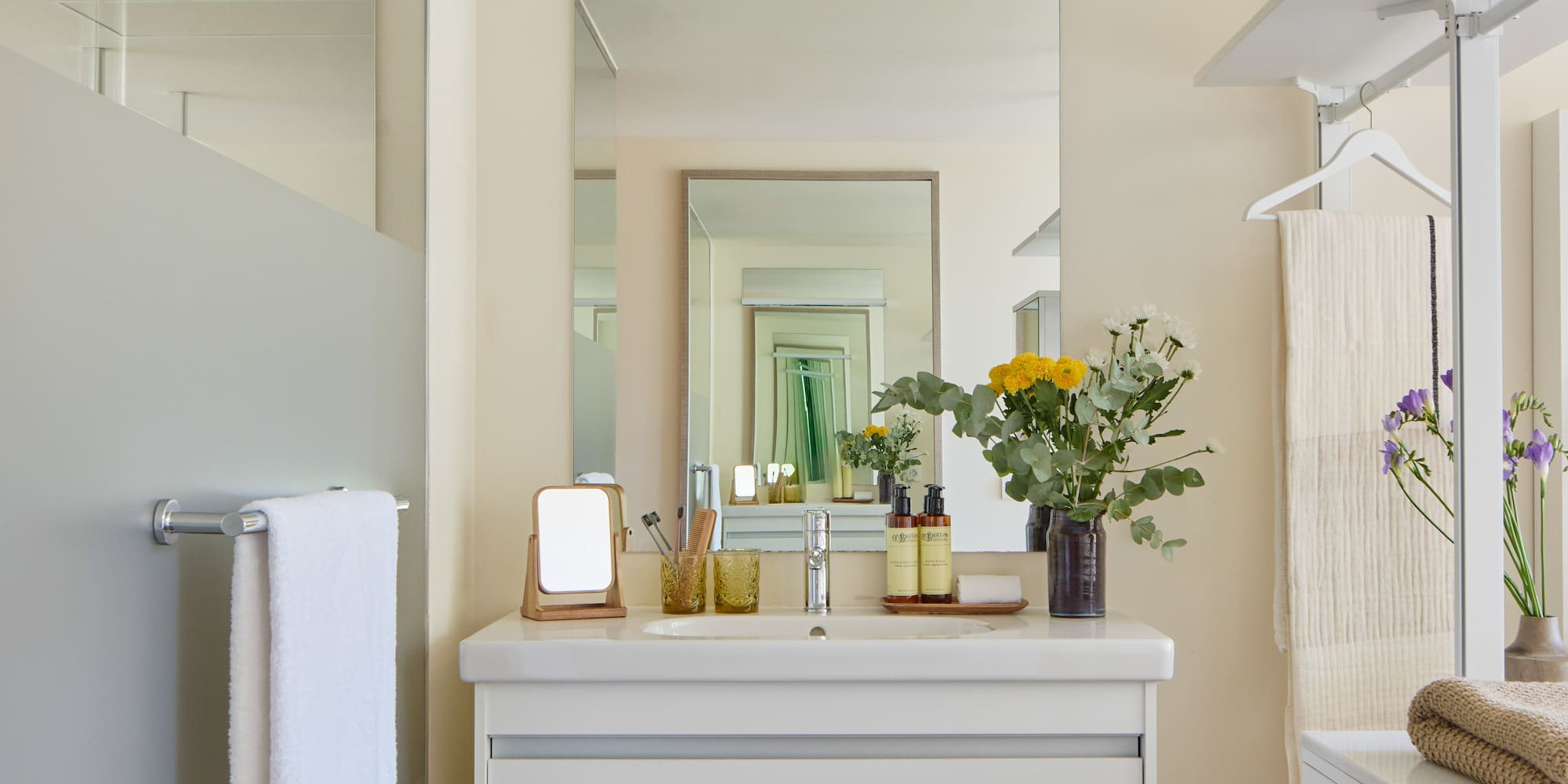 a bathroom with a mirror and flowers