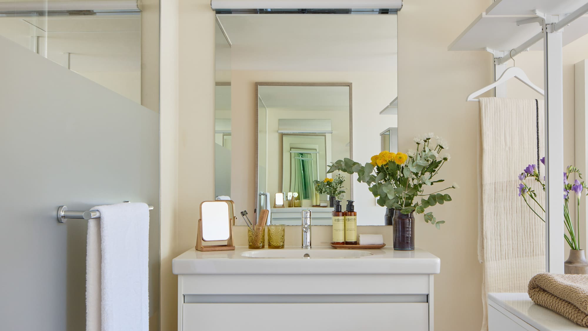 a bathroom with a mirror and flowers