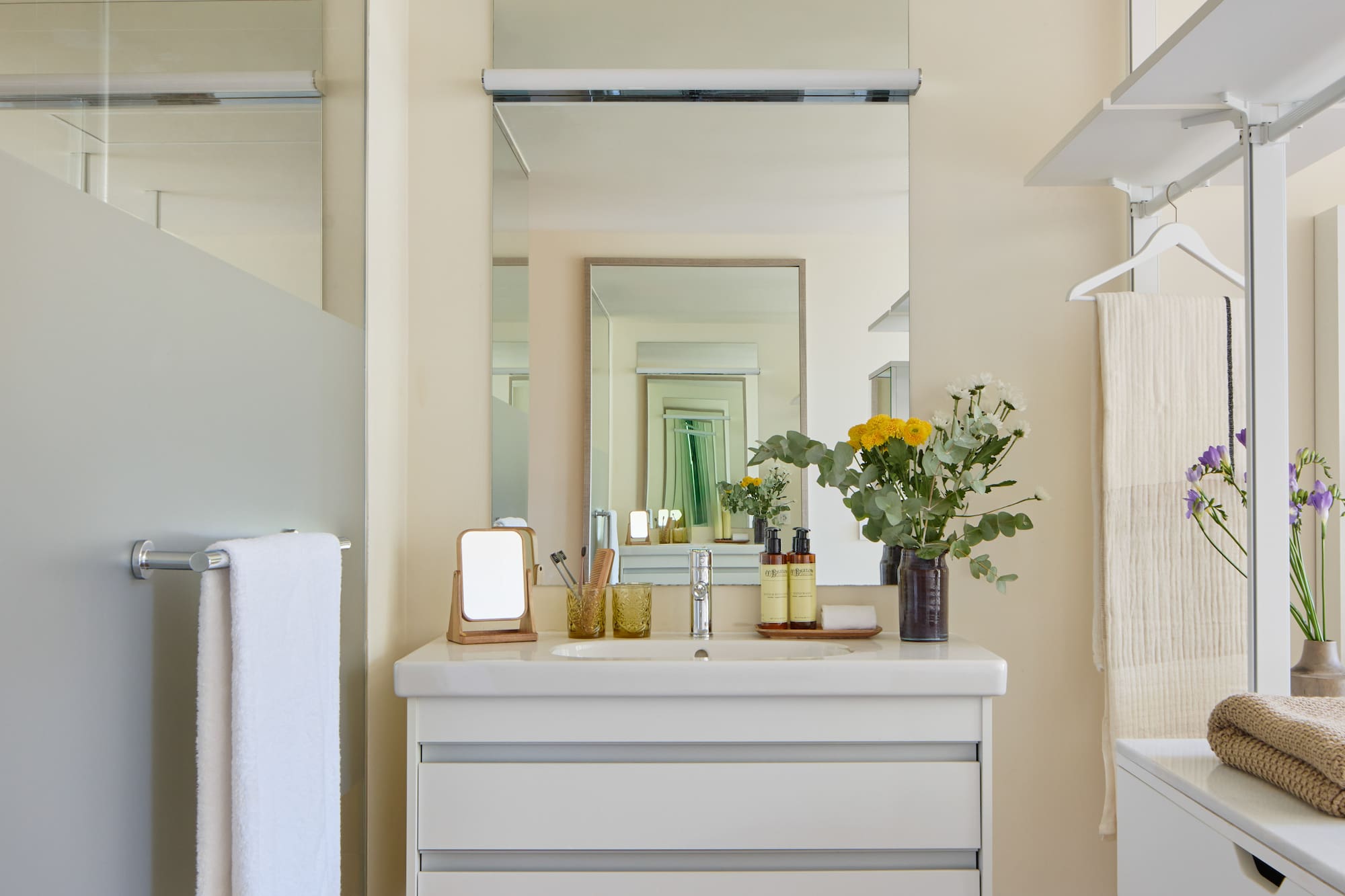a bathroom with a mirror and flowers