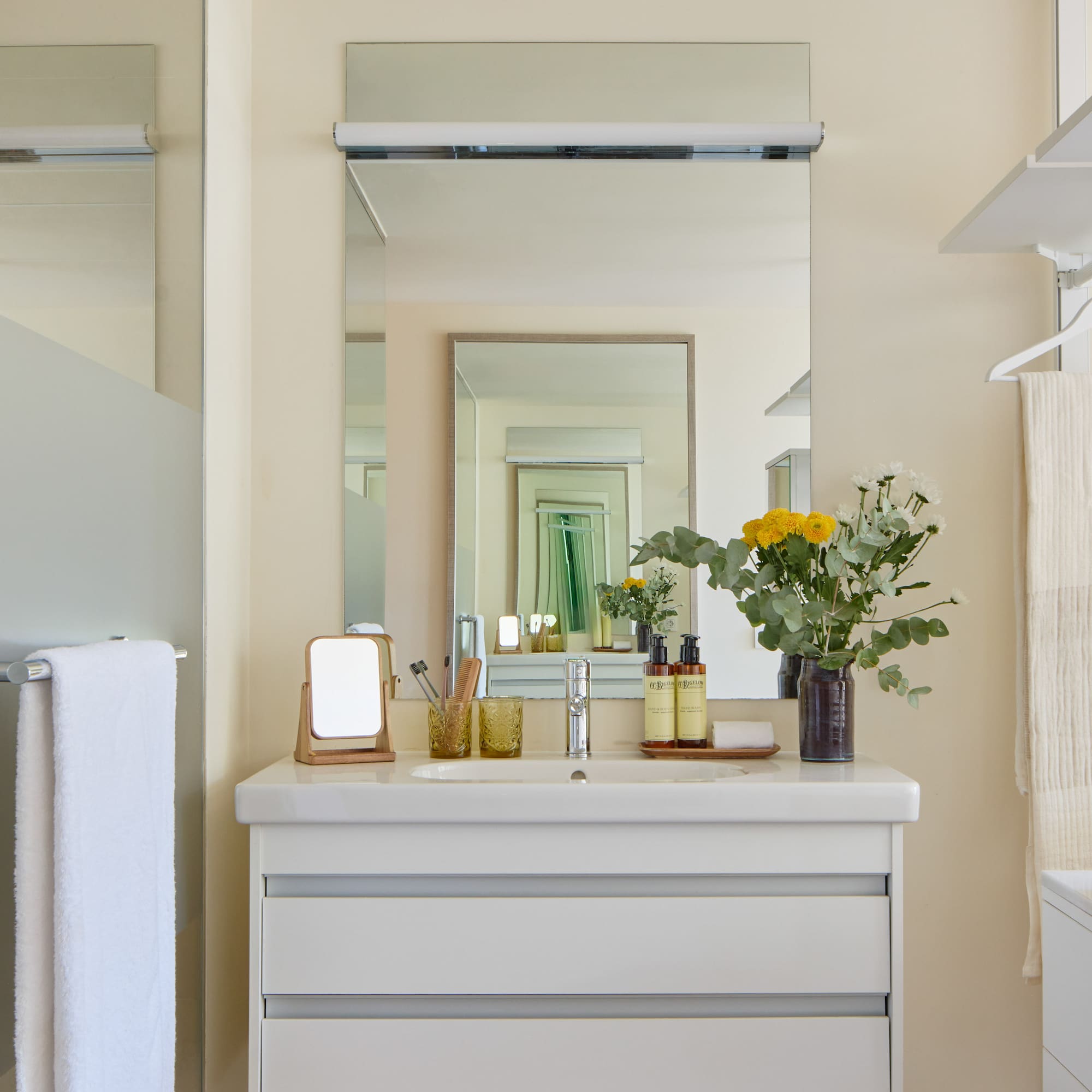 a bathroom with a mirror and flowers