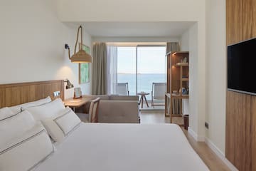 a room with a bed and a table and chairs