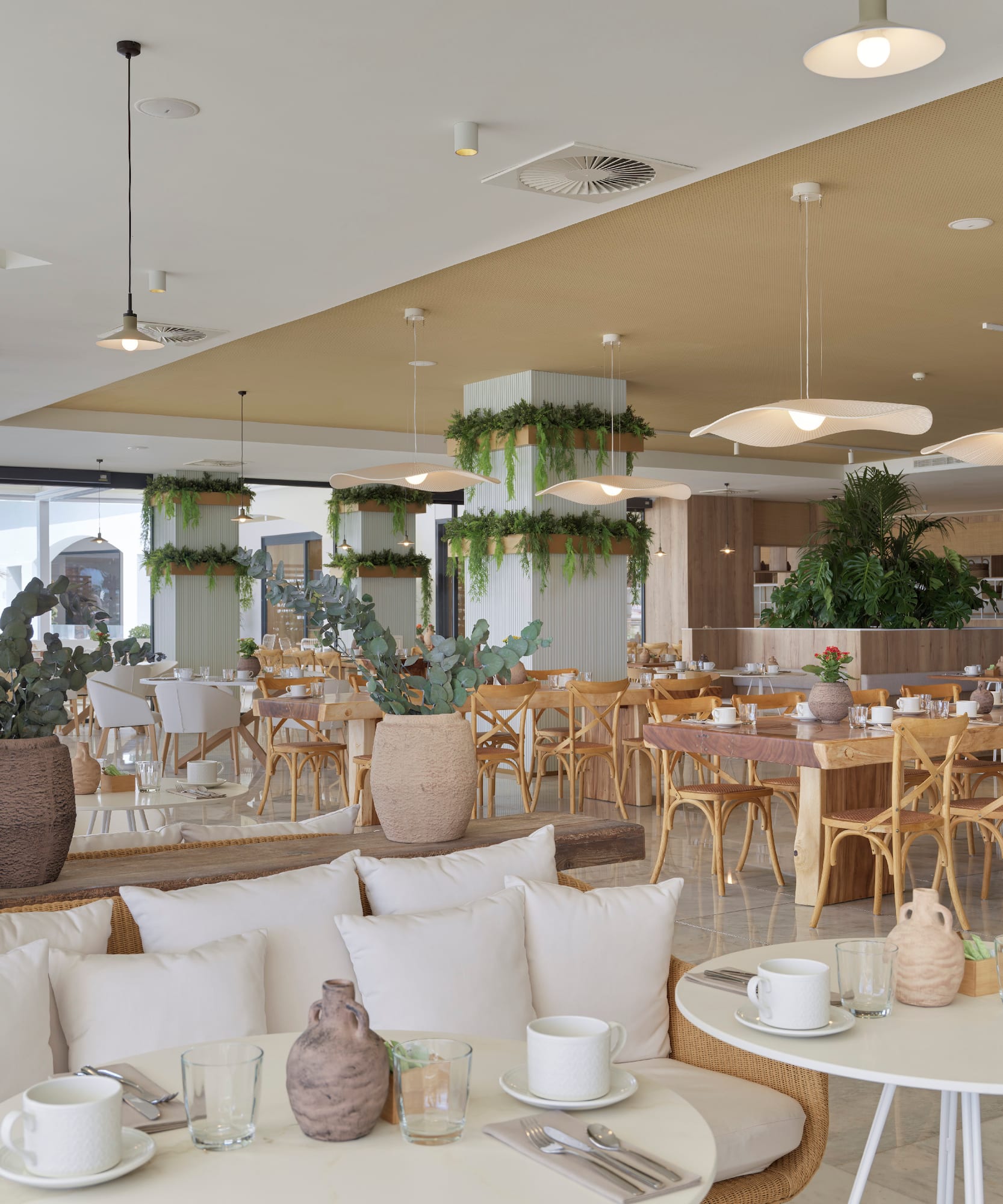 a room with tables and chairs and plants