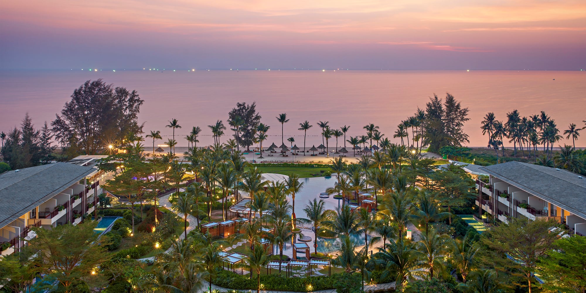a resort with palm trees and a beach