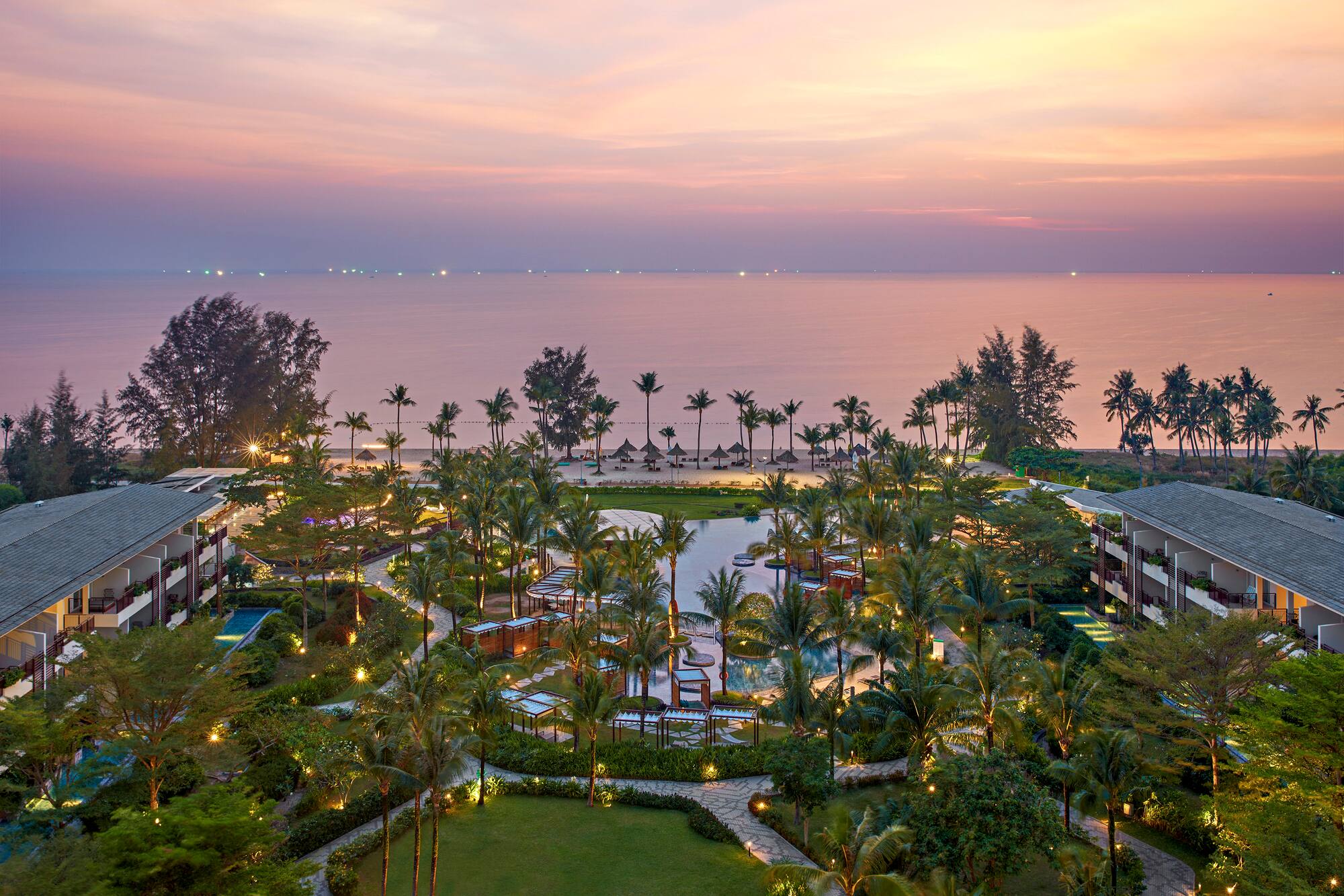 a resort with palm trees and a beach