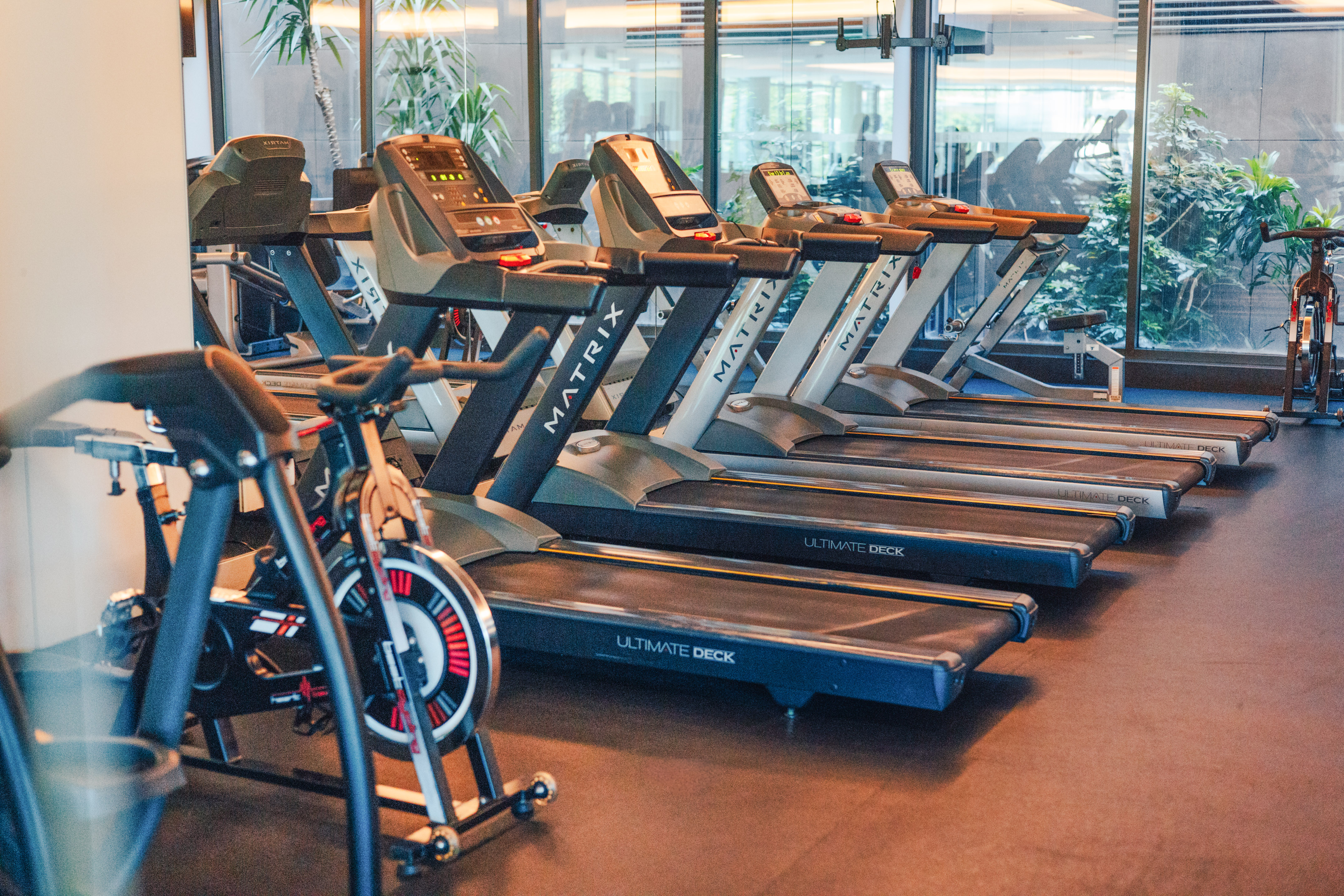 Matrix Ultimate Deck treadmills and exercise bike in a modern gym.