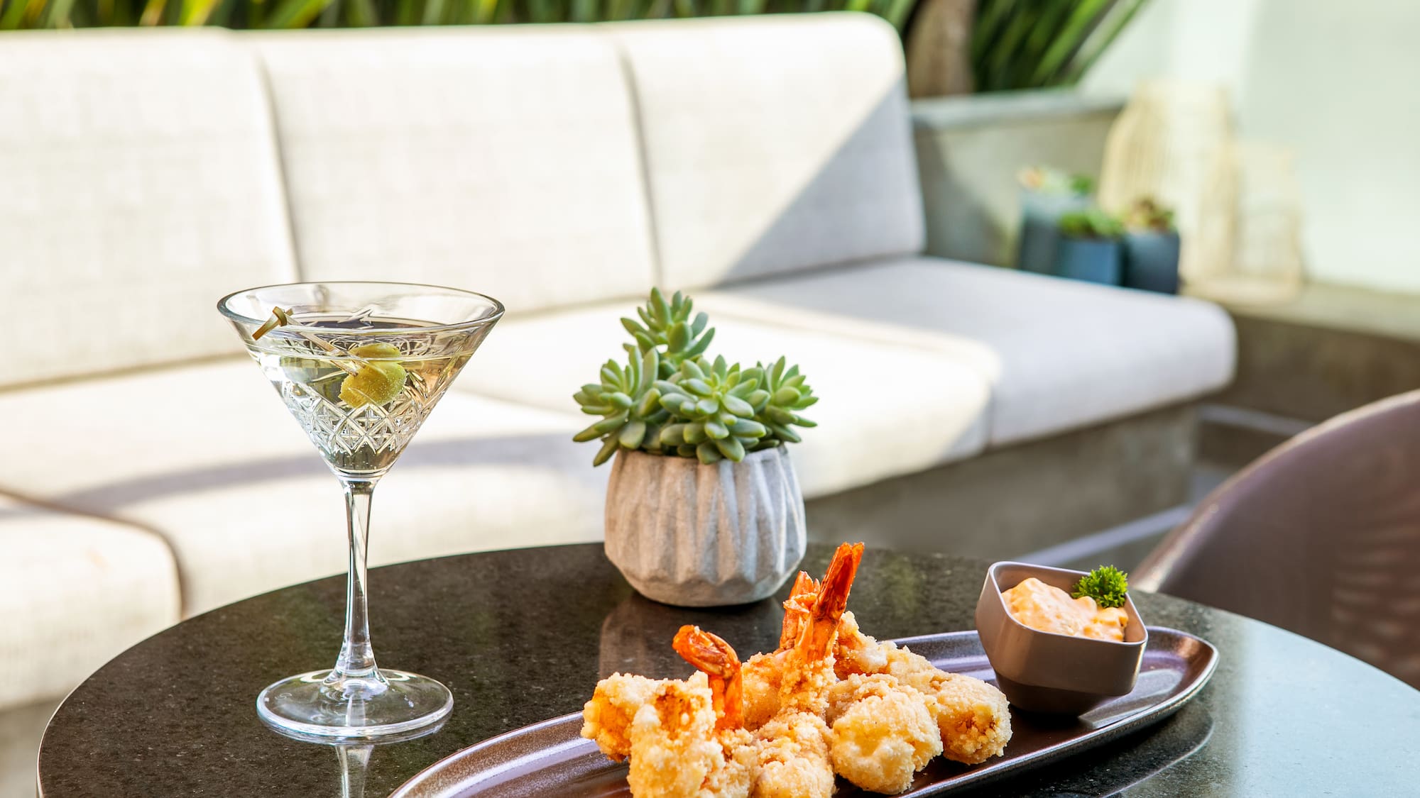 a plate of fried shrimp and a martini glass on a table