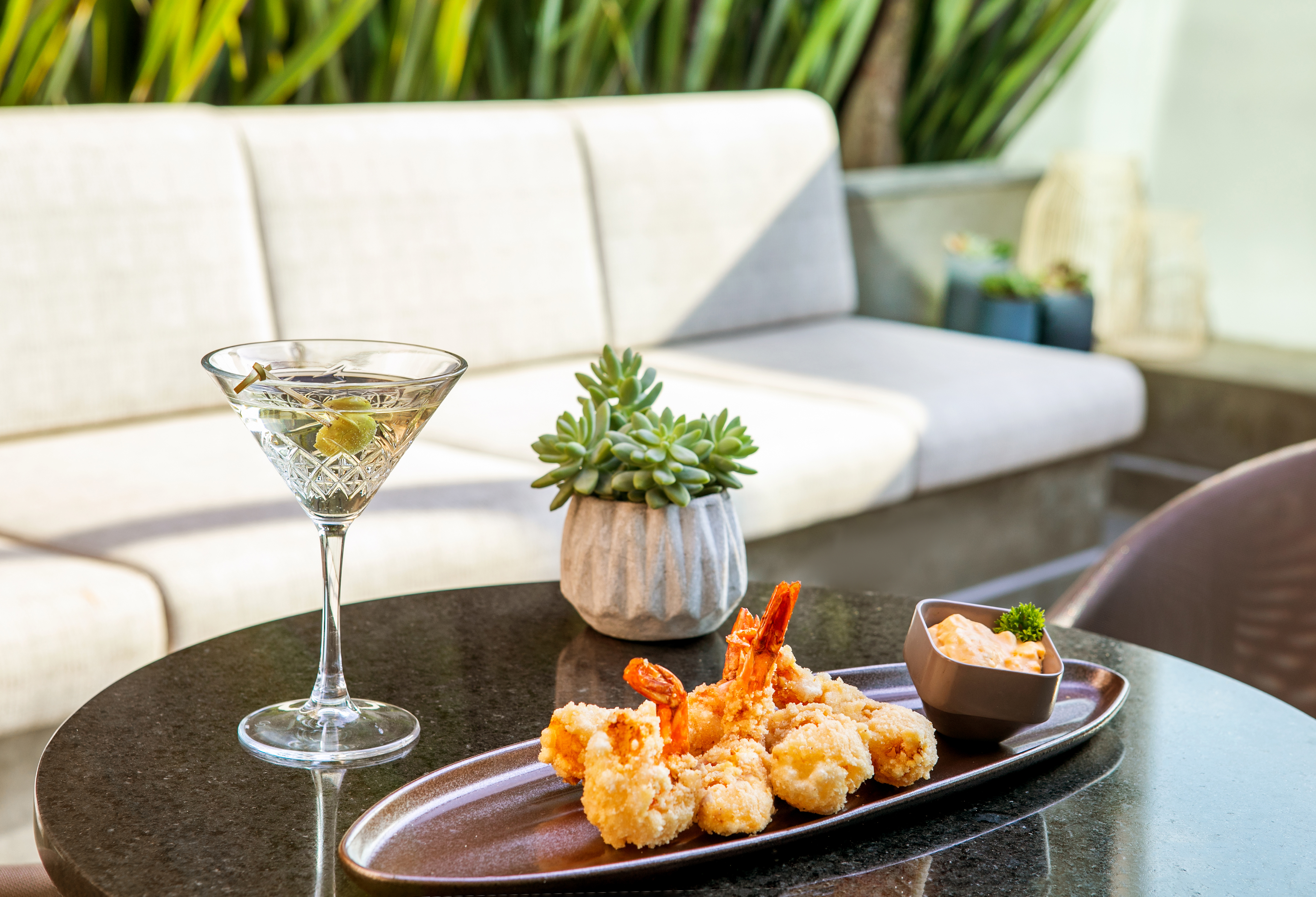 a plate of fried shrimp and a martini glass on a table