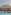 Mediterranean resort hotel with large pool, lounge chairs, and palm trees.