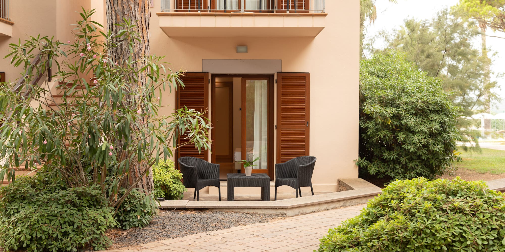 a patio area with chairs and a table in front of a building