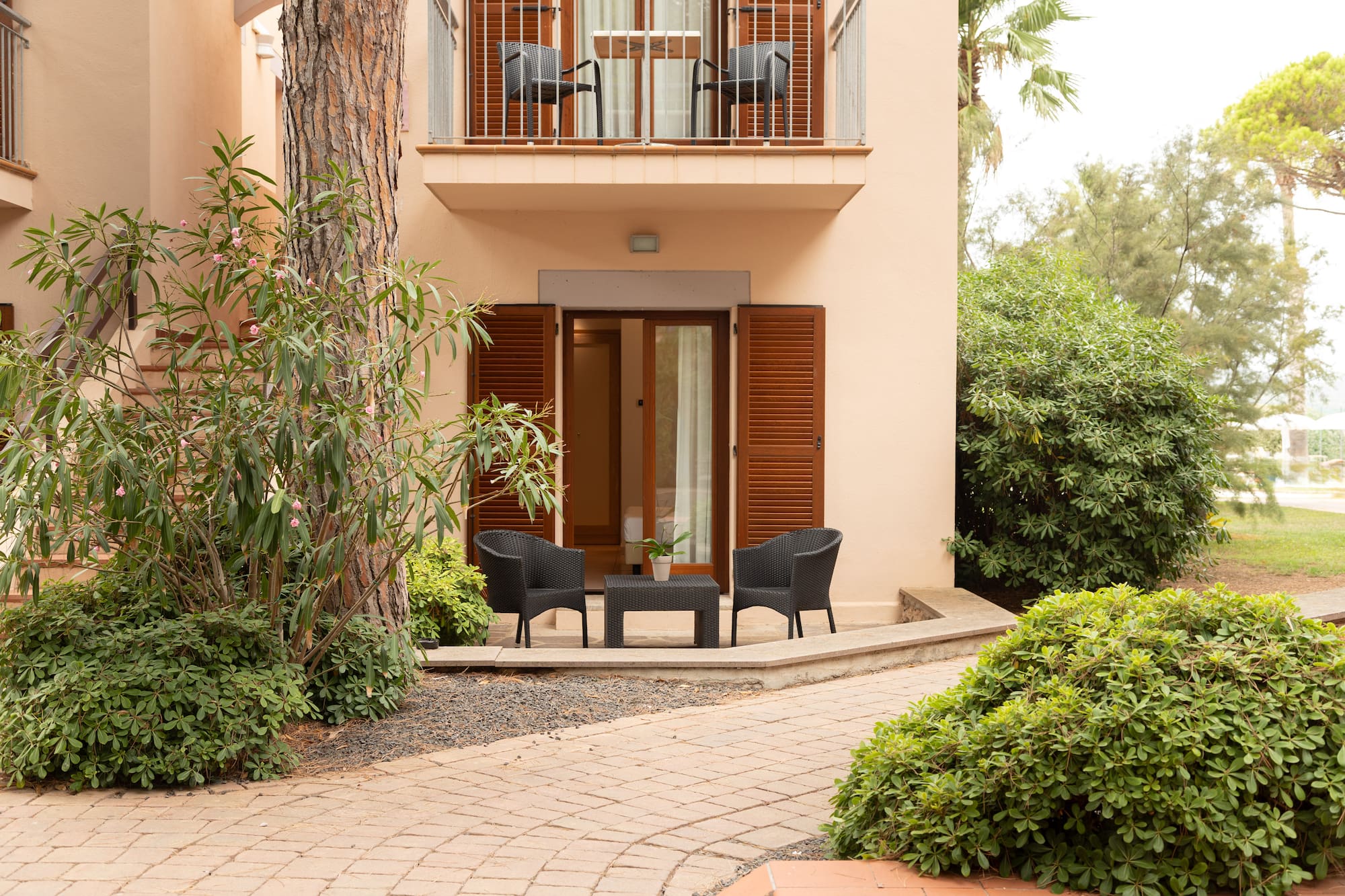 a patio area with chairs and a table in front of a building