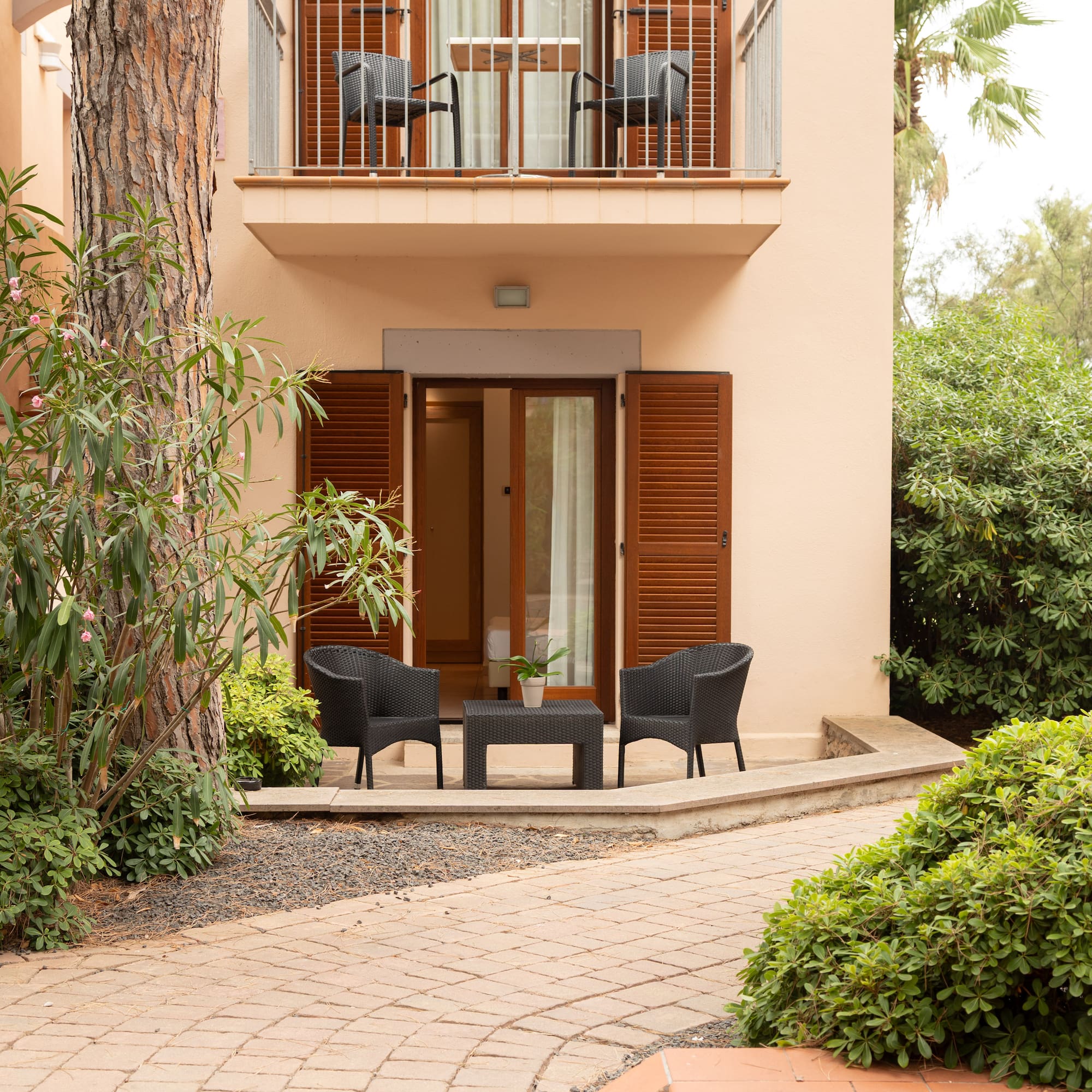 a patio area with chairs and a table in front of a building