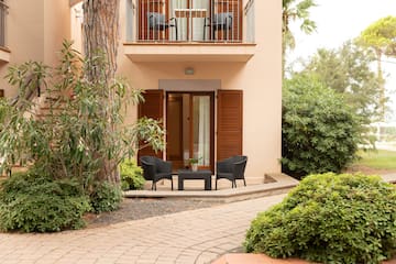 a patio area with chairs and a table in front of a building