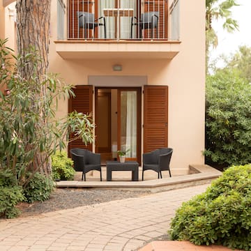 a patio area with chairs and a table in front of a building