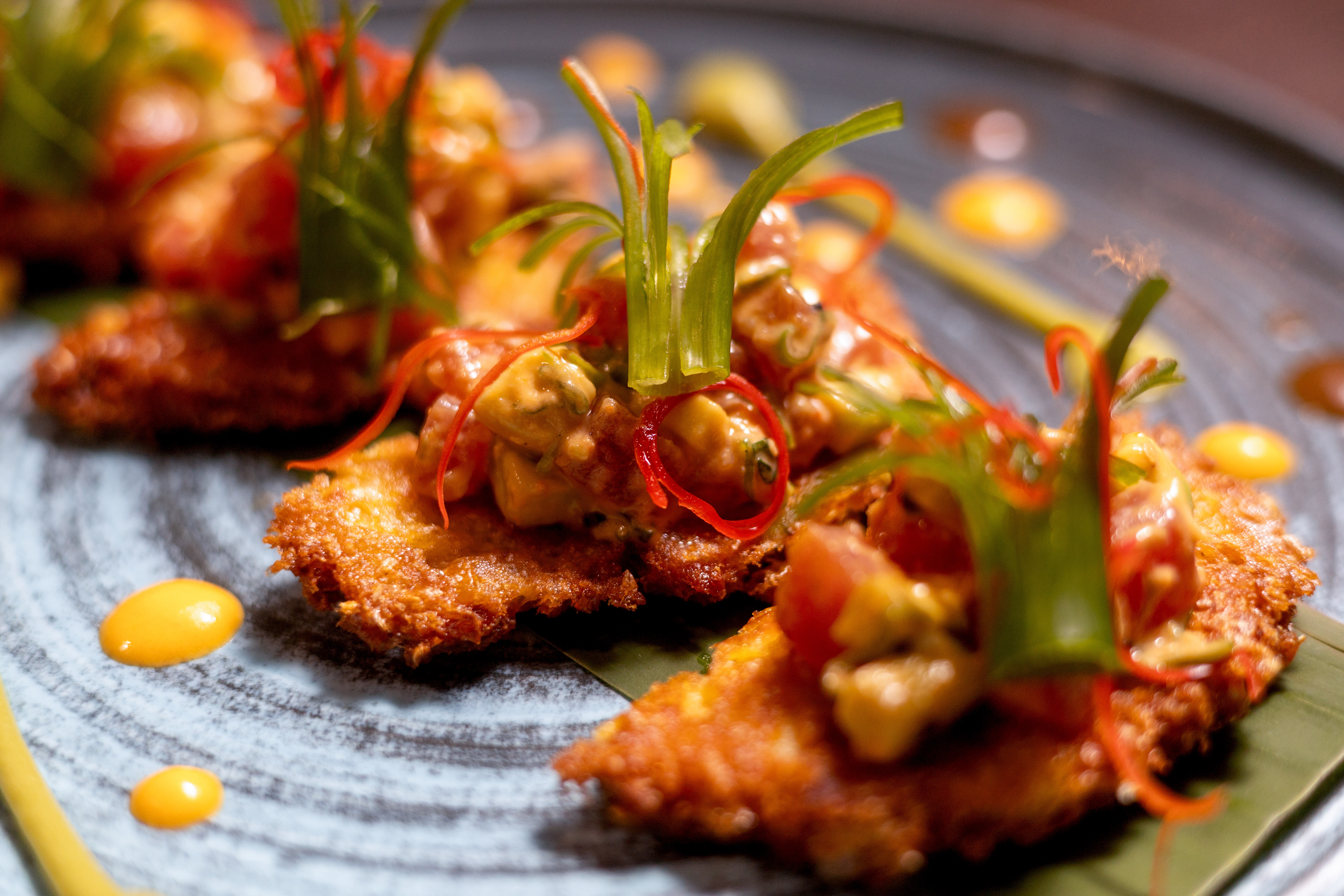 Golden fried appetizers with avocado salsa, chili, and fresh herbs.