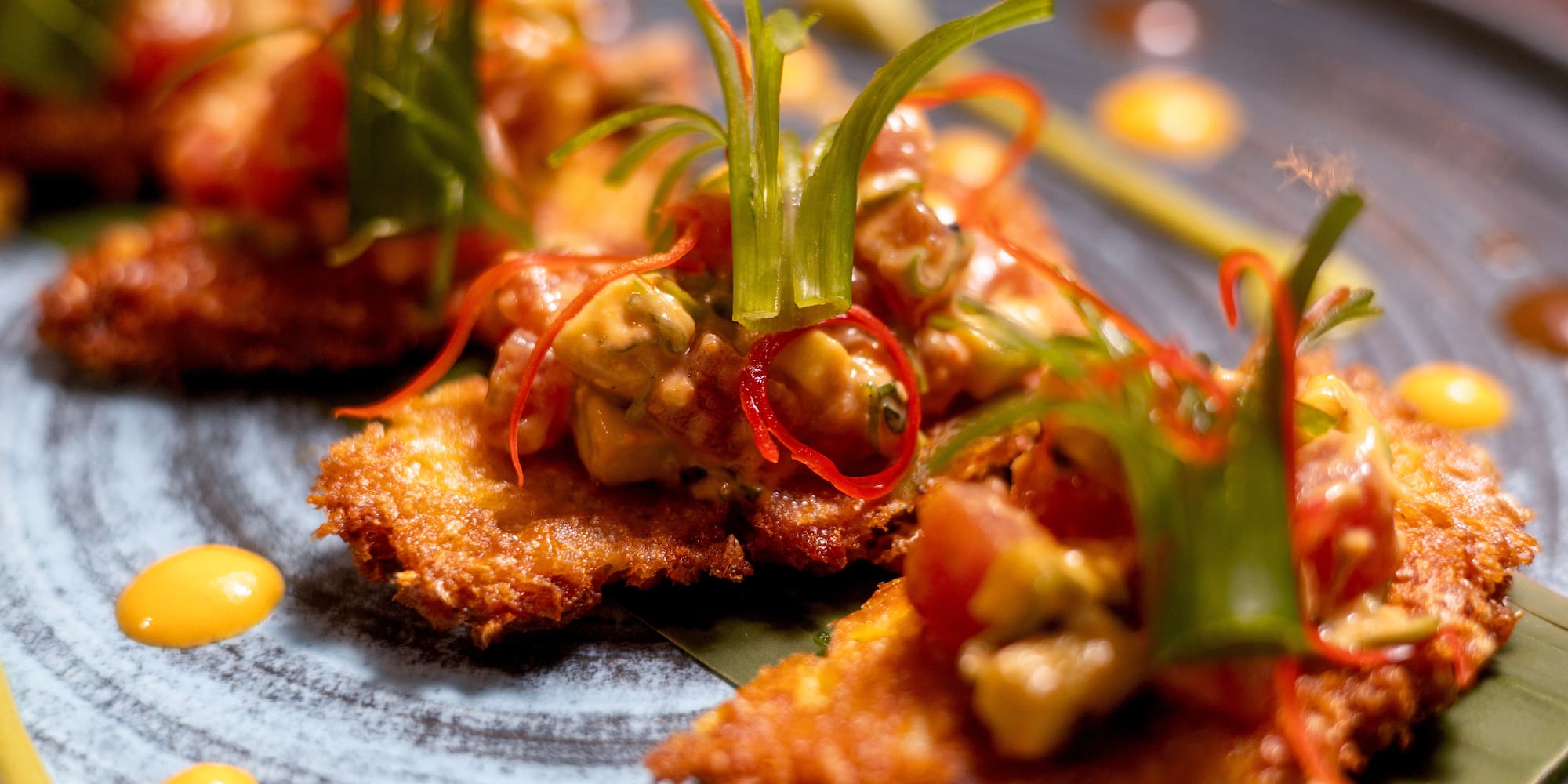 Golden fried appetizers with avocado salsa, chili, and fresh herbs.