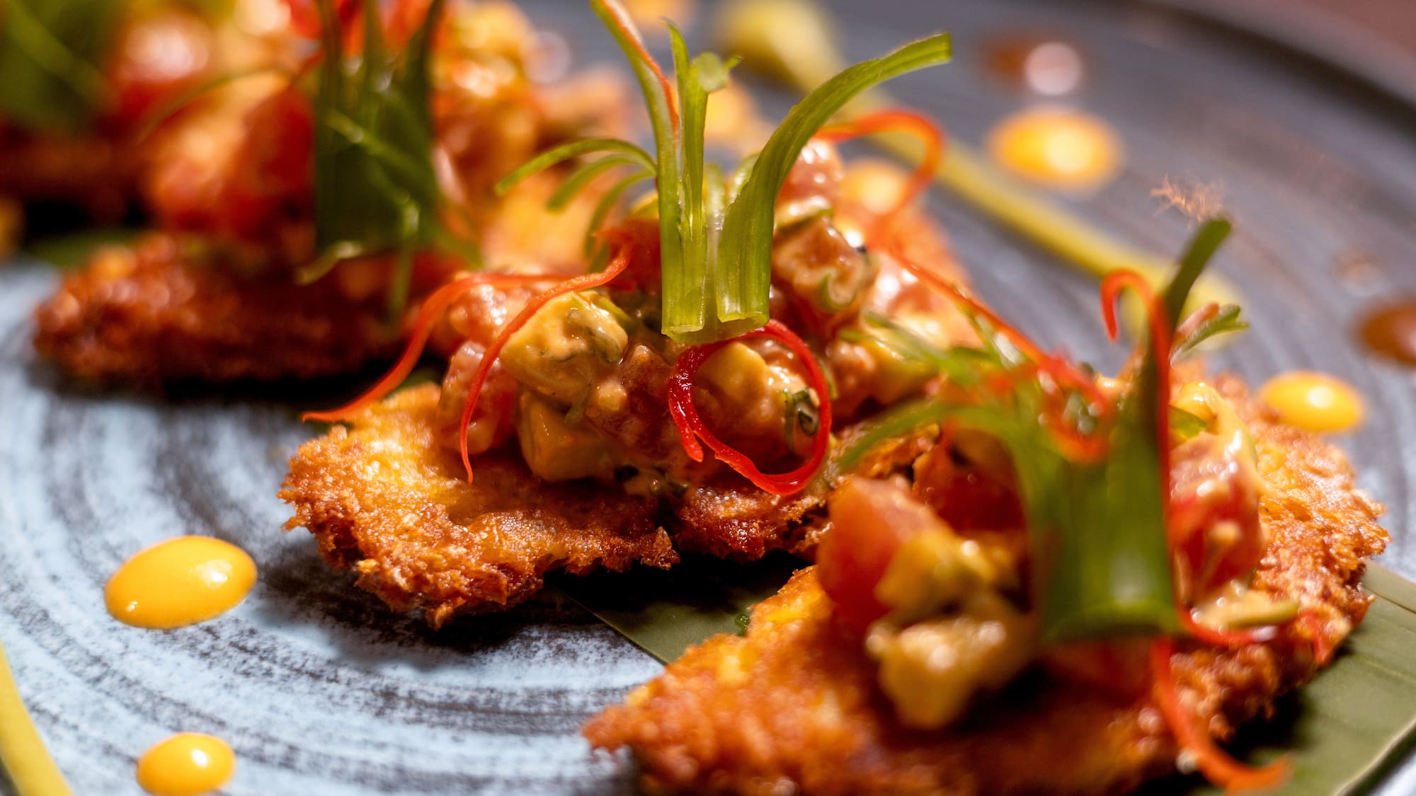 Golden fried appetizers with avocado salsa, chili, and fresh herbs.