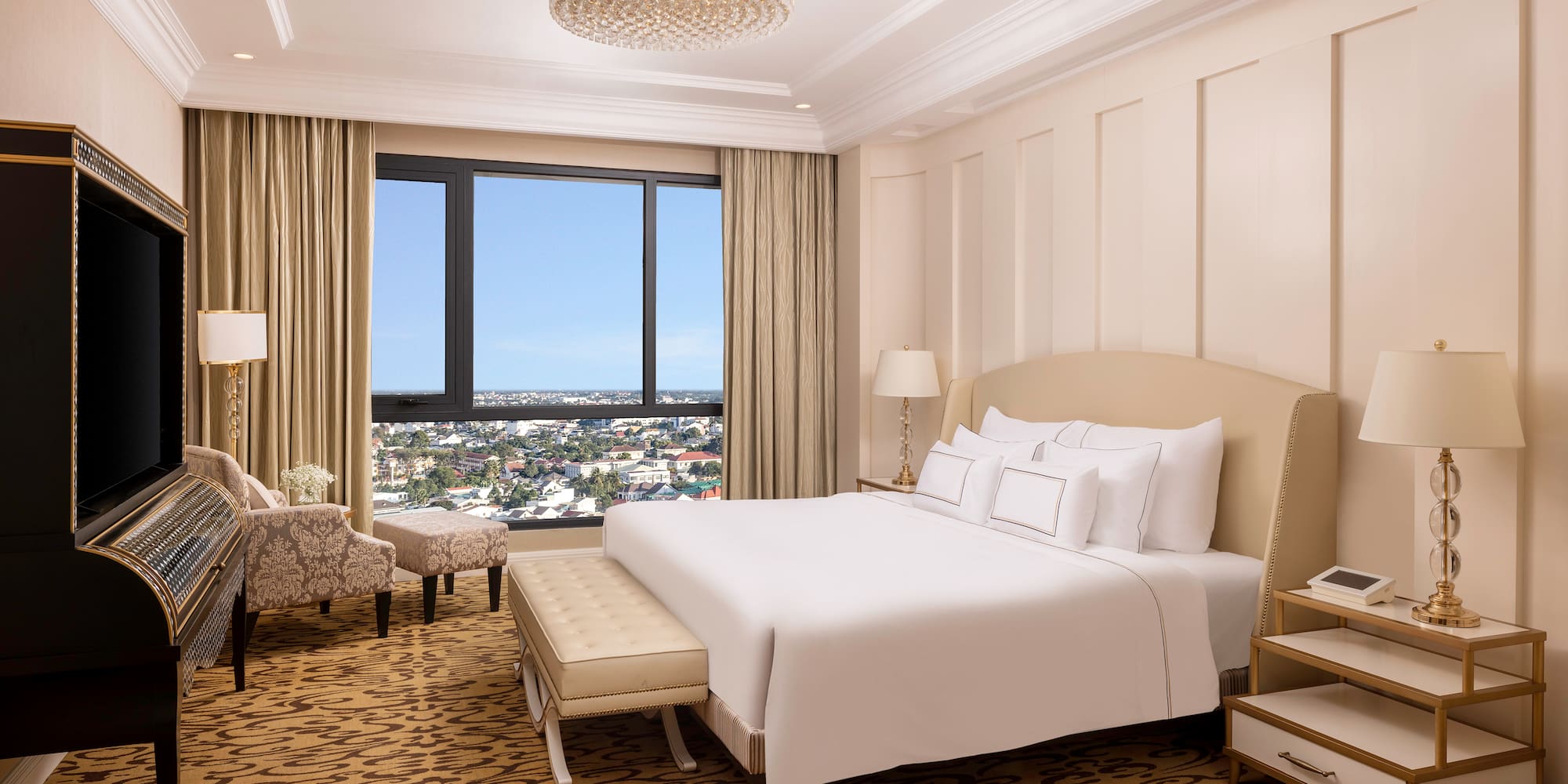 a bedroom with a large bed and a chandelier