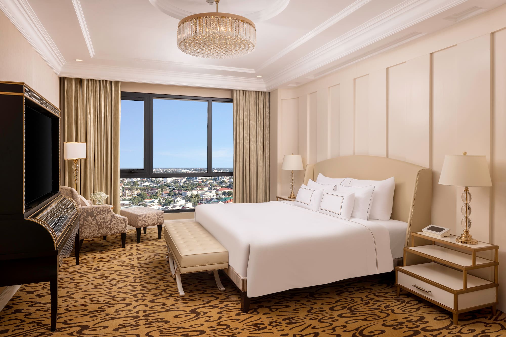 a bedroom with a large bed and a chandelier
