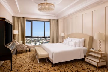 a bedroom with a large bed and a chandelier