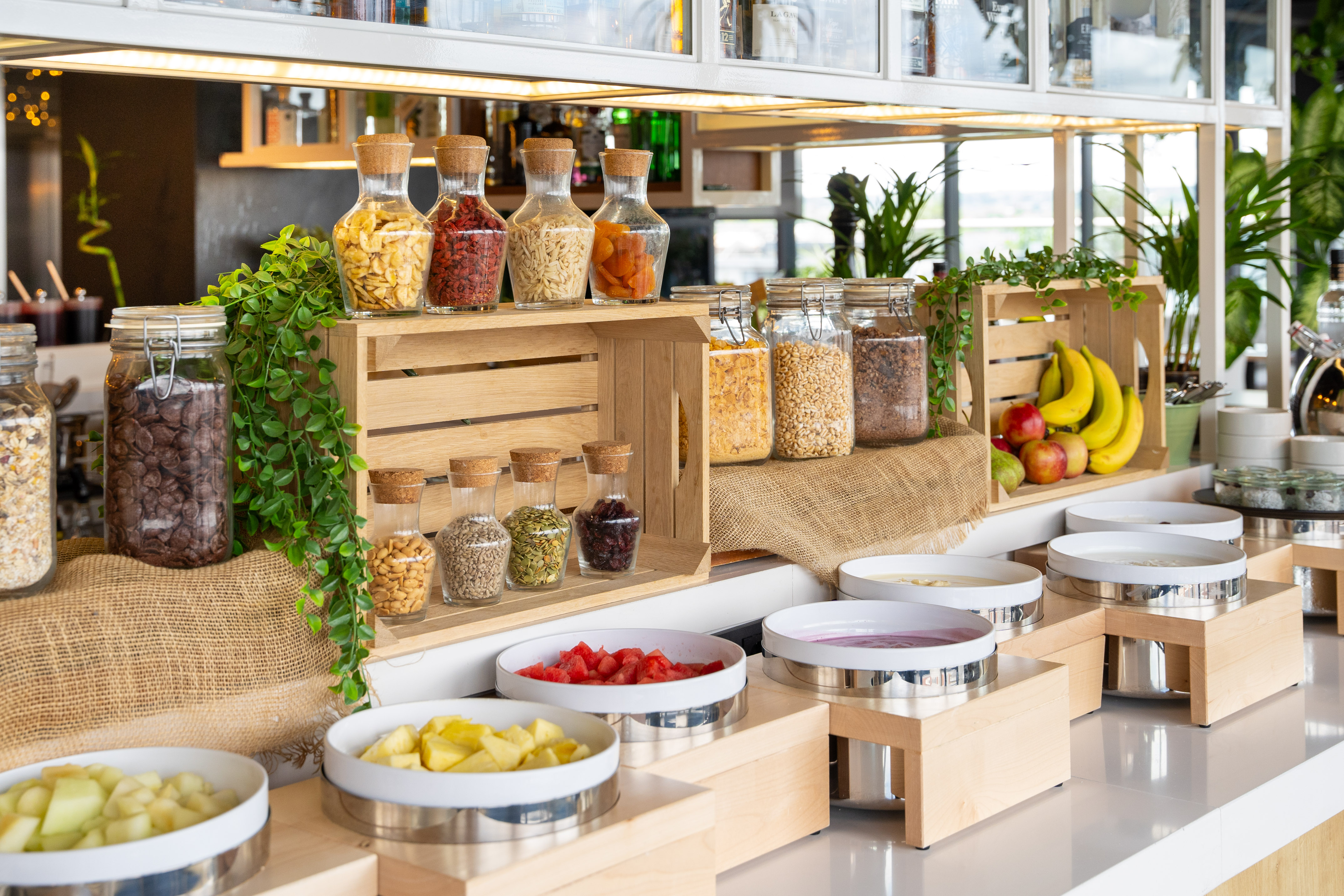 Healthy self-serve breakfast buffet with cereals, fruits, nuts, and yogurts.