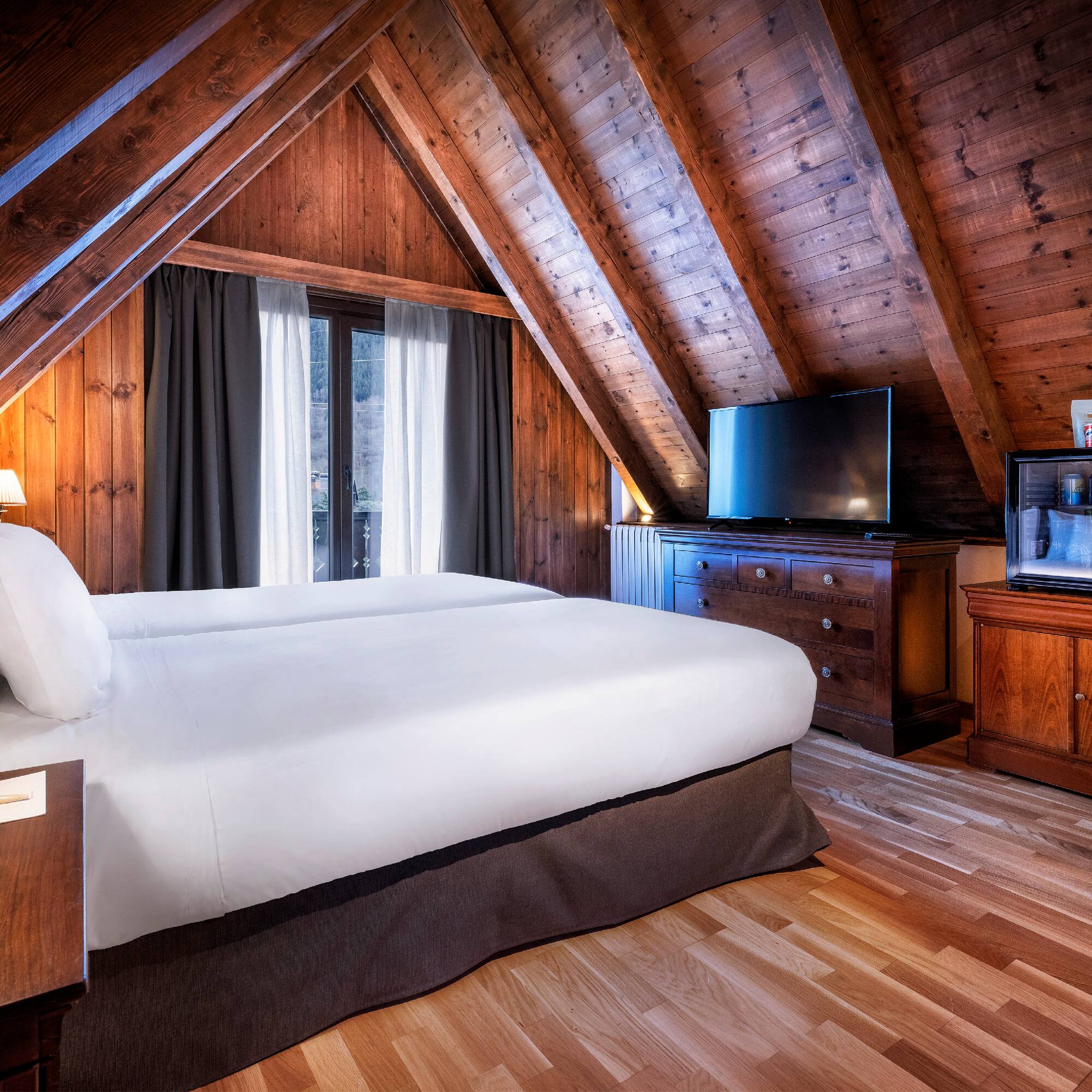 a bedroom with a wooden ceiling and a tv