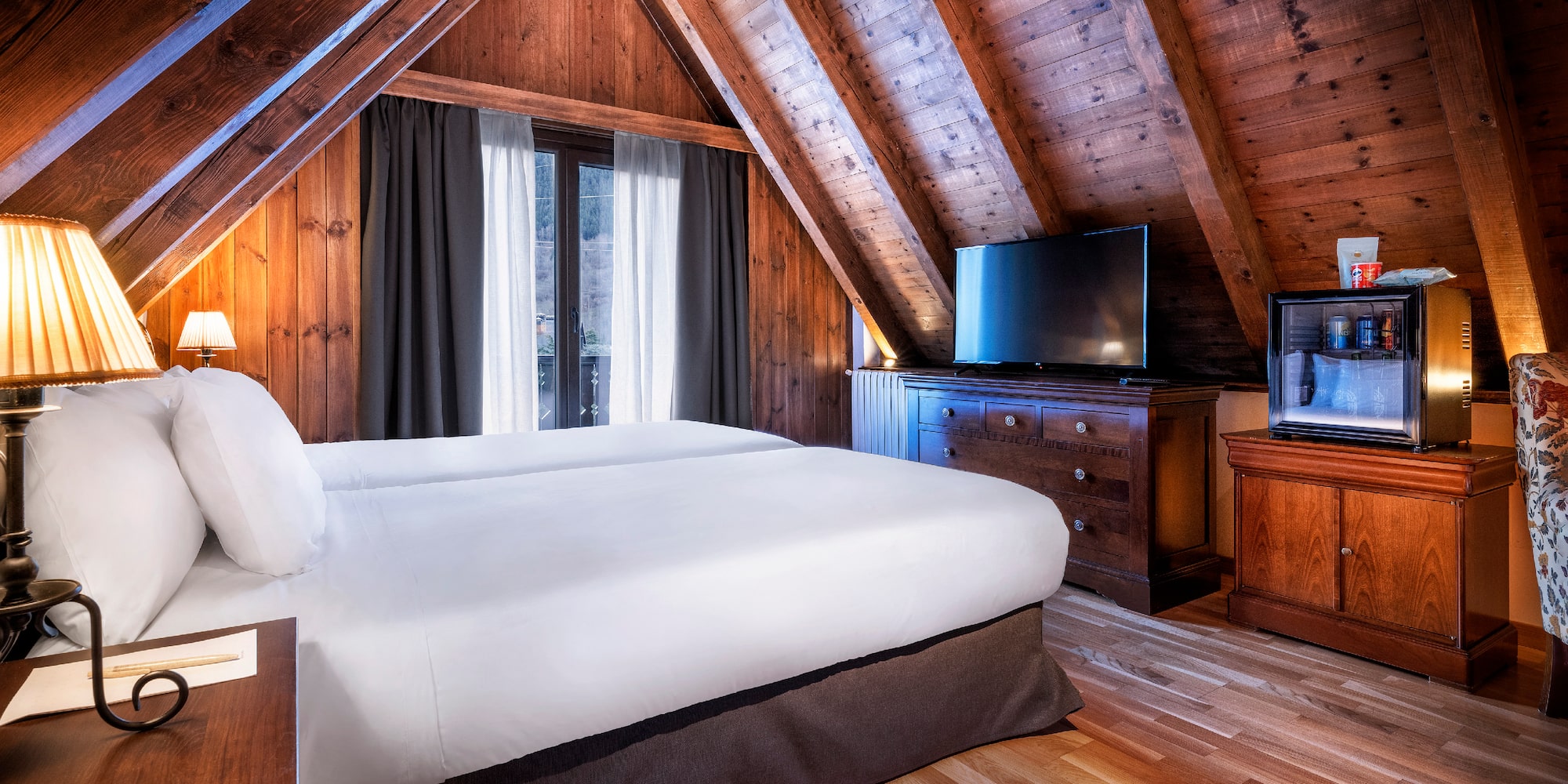 a bedroom with a wooden ceiling and a tv