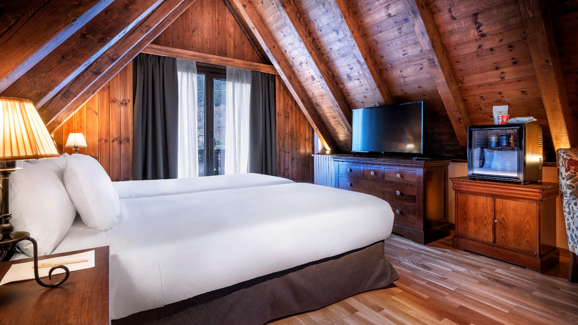 a bedroom with a wooden ceiling and a tv